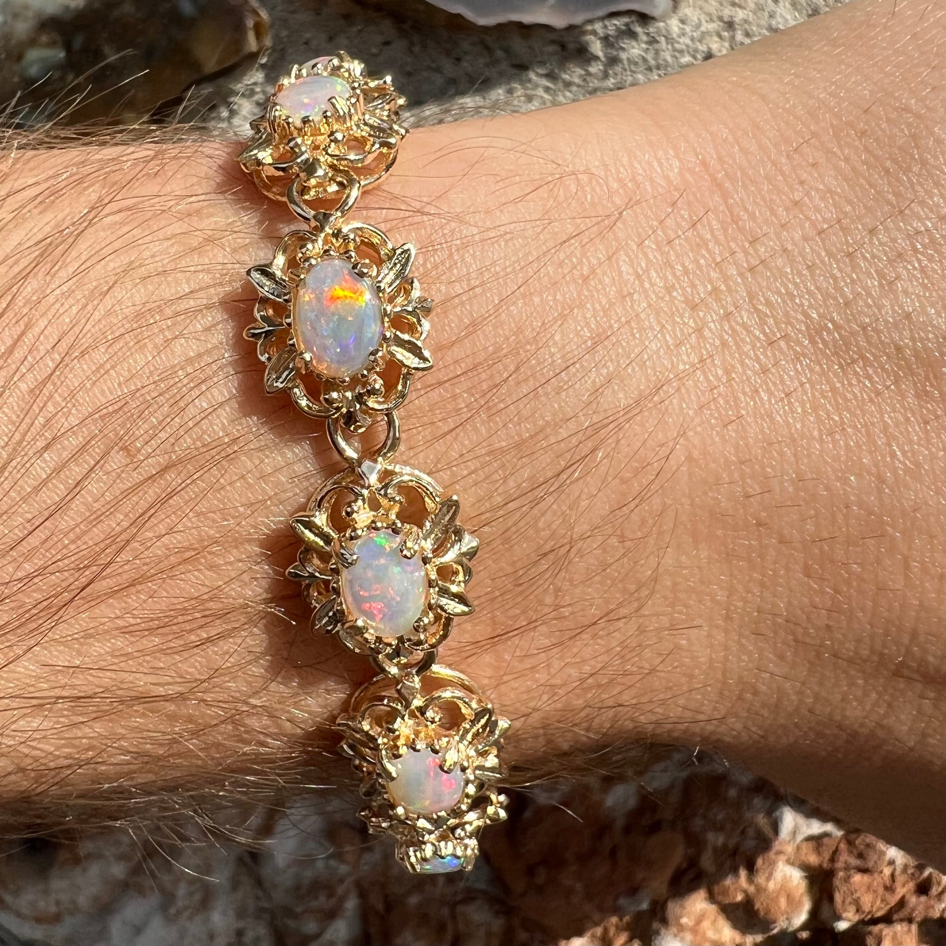 A ladies' yellow gold bracelet set with natural, oval cabochon cut white crystal opals.