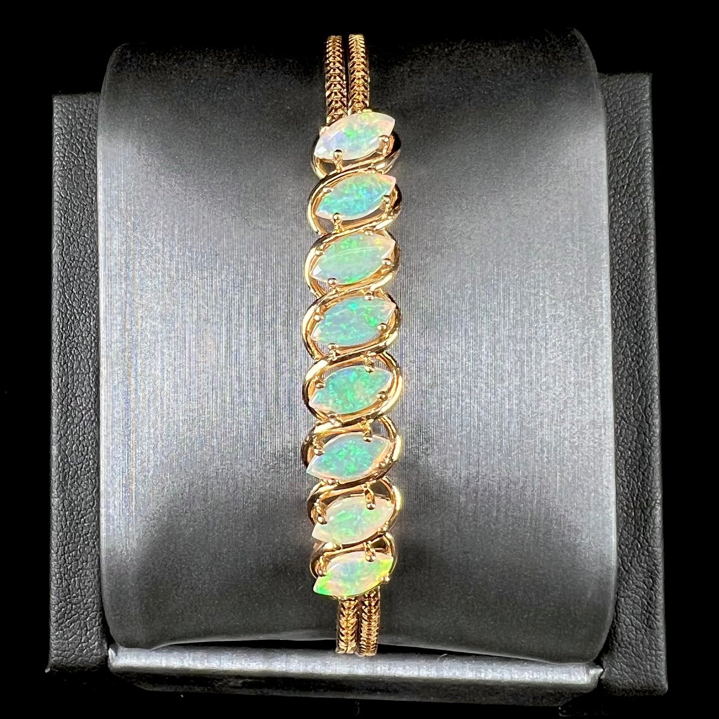 A ladies' yellow gold bracelet prong set with eight natural, marquise cabochon cut opals.