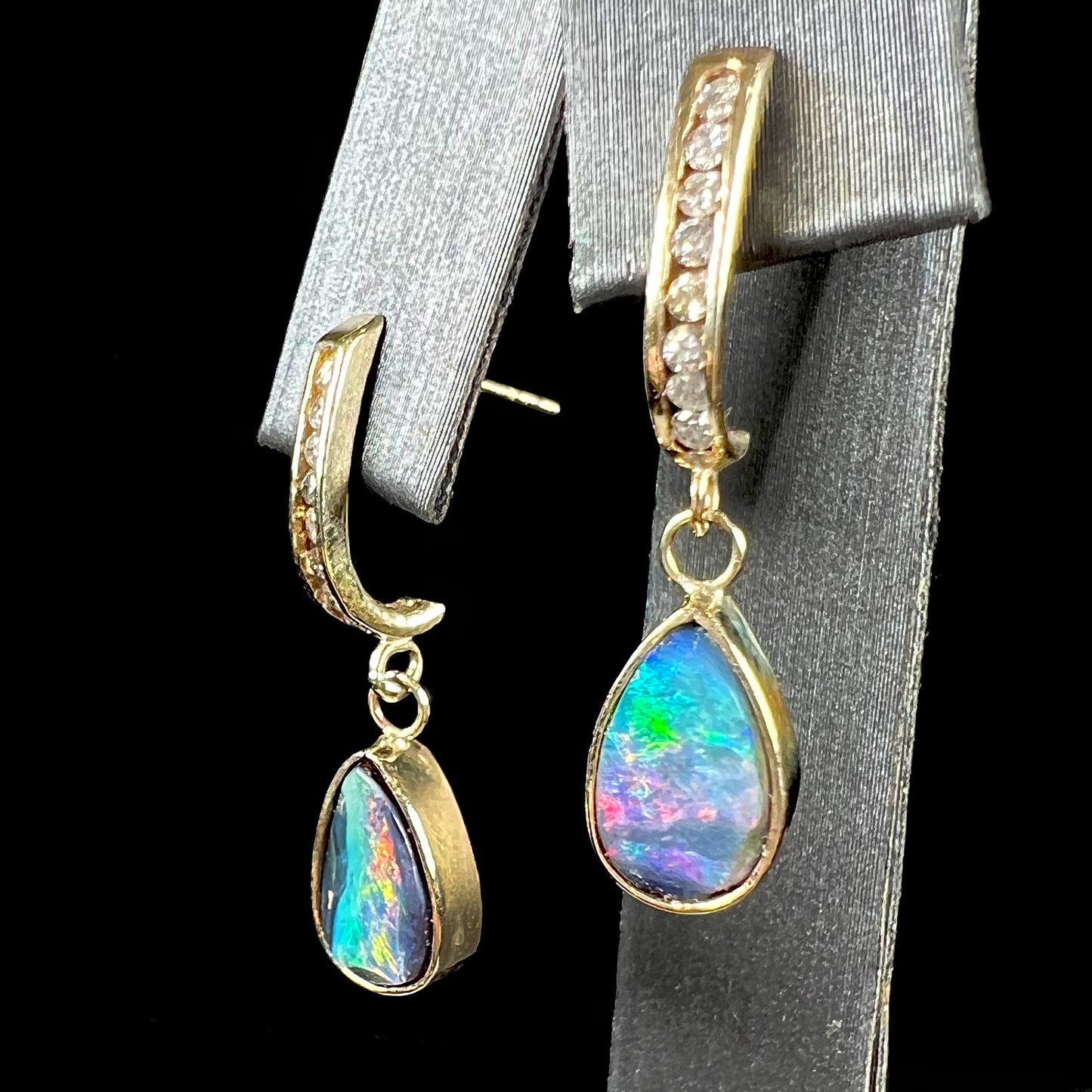 A pair of yellow gold dangle earrings set with natural pear shaped boulder opals and diamonds.