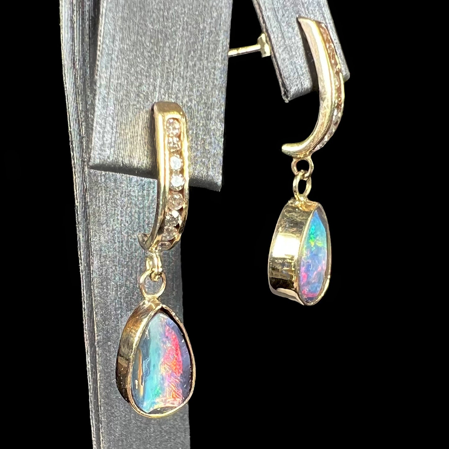 A pair of yellow gold dangle earrings set with natural pear shaped boulder opals and diamonds.