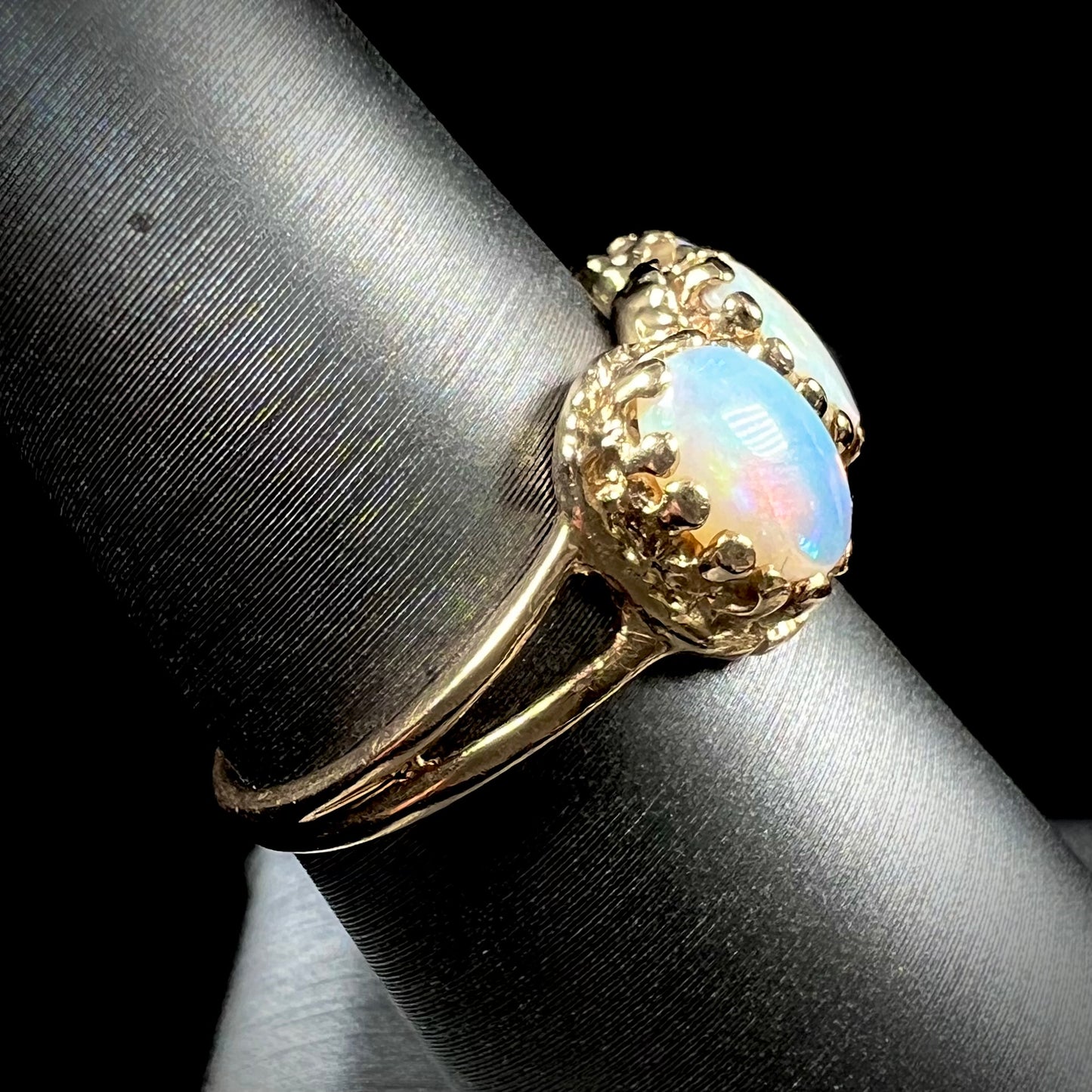 A vintage ladies' three stone gold ring set with natural white crystal opals.