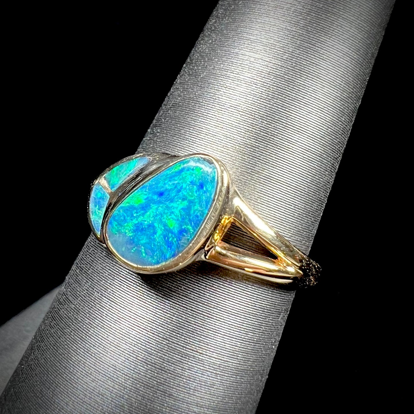 A ladies' black opal inlay ring cast in yellow gold.