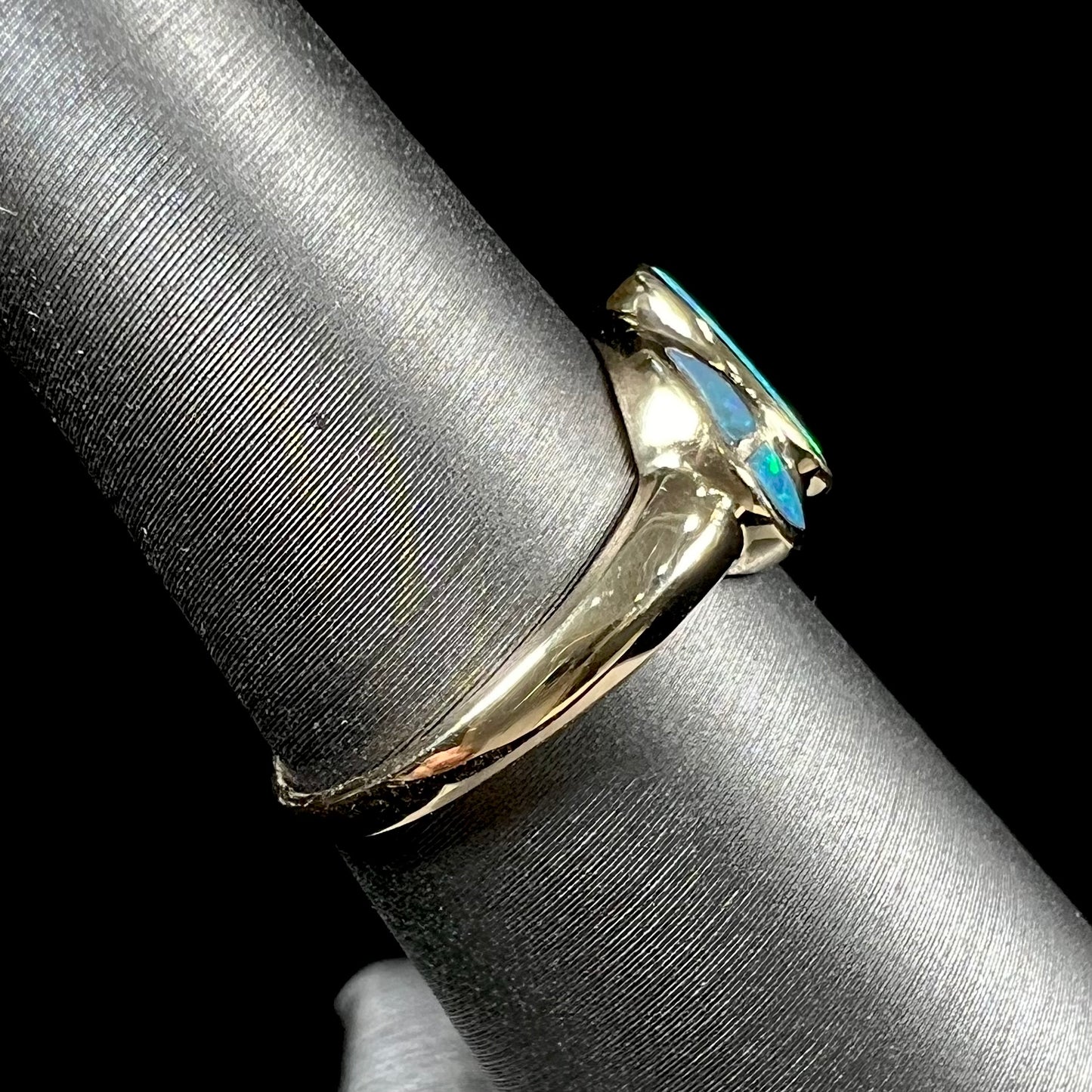 A ladies' black opal inlay ring cast in yellow gold.