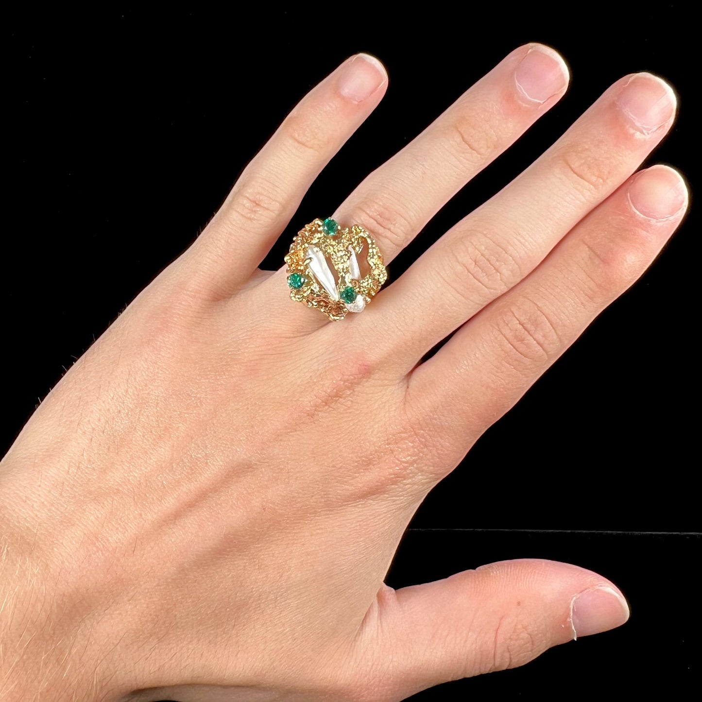 A vintage 1950's gold cluster ring set with freshwater pearls and green imitation emeralds.