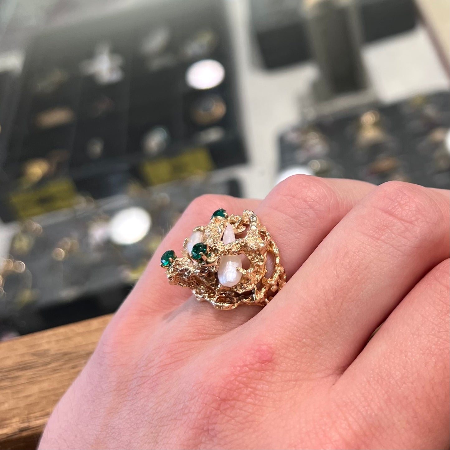 A vintage 1950's gold cluster ring set with freshwater pearls and green imitation emeralds.