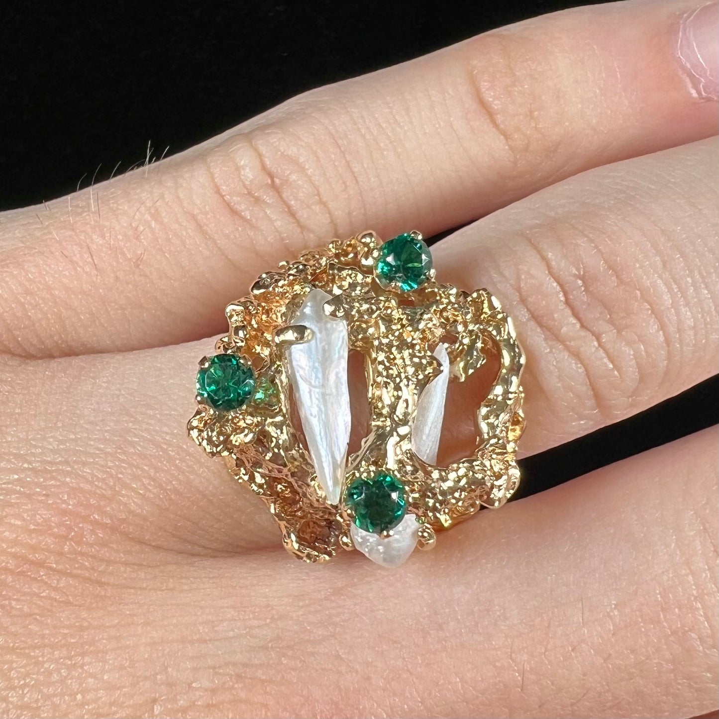 A vintage 1950's gold cluster ring set with freshwater pearls and green imitation emeralds.