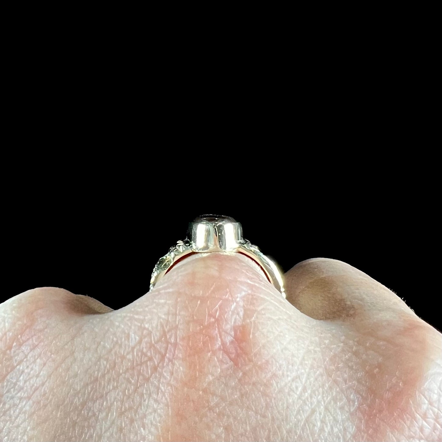 A unisex oval cabochon cut fire agate ring cast in yellow gold. The stone flashes green and red colors.