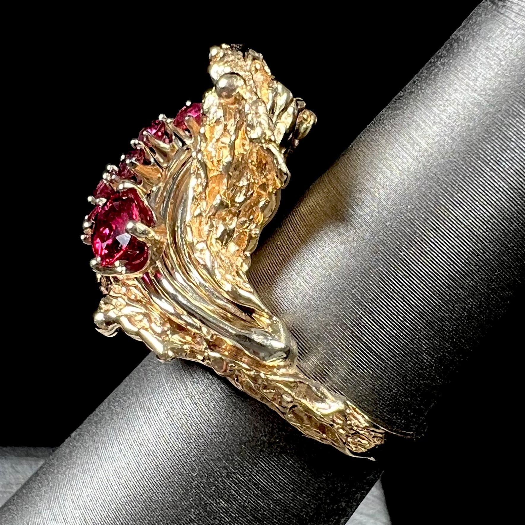 A yellow gold ruby cluster ring from the 1950's.  There is one oval cut ruby and five round cut rubies.
