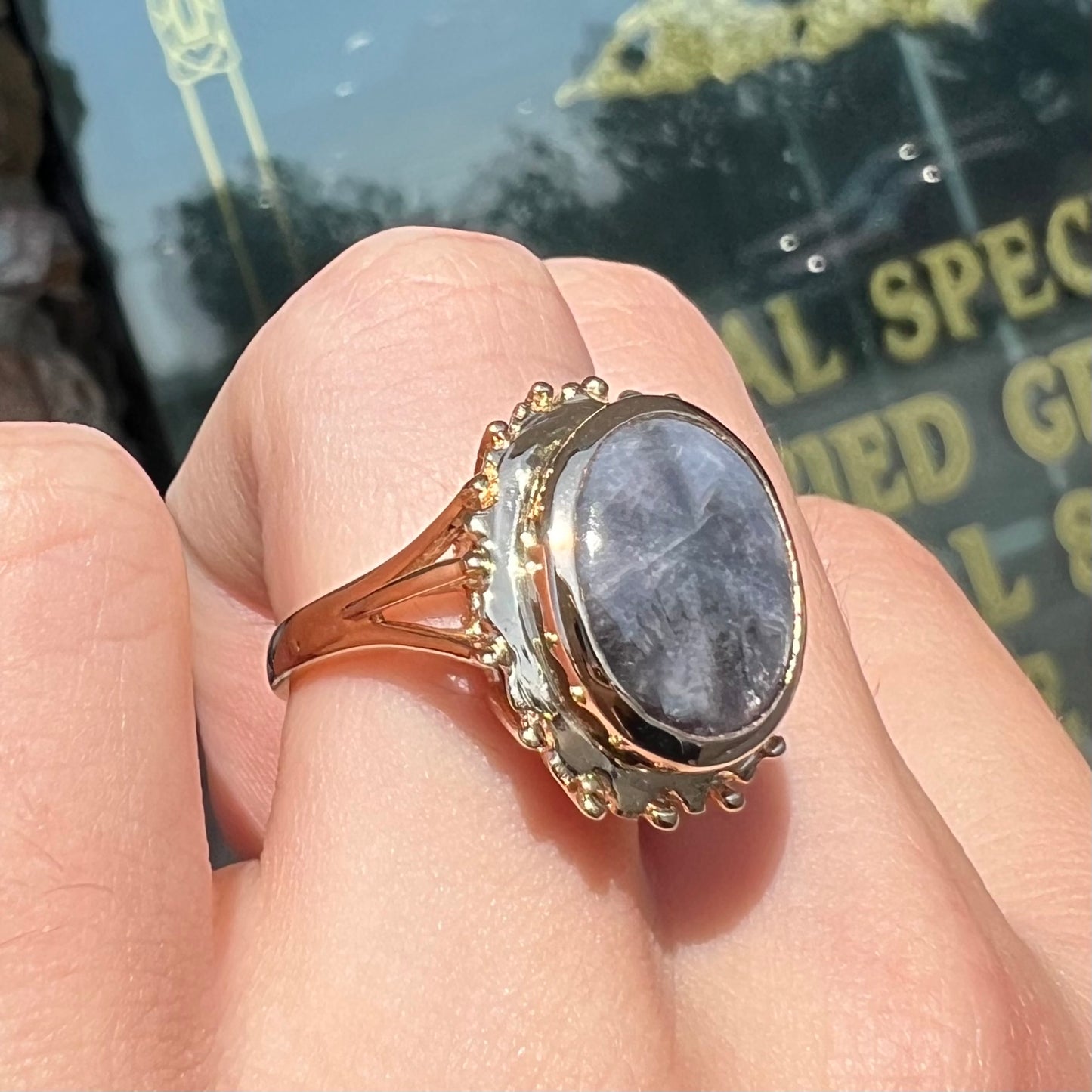 A ladies' yellow gold solitaire ring mounted with a gray trapiche star sapphire.