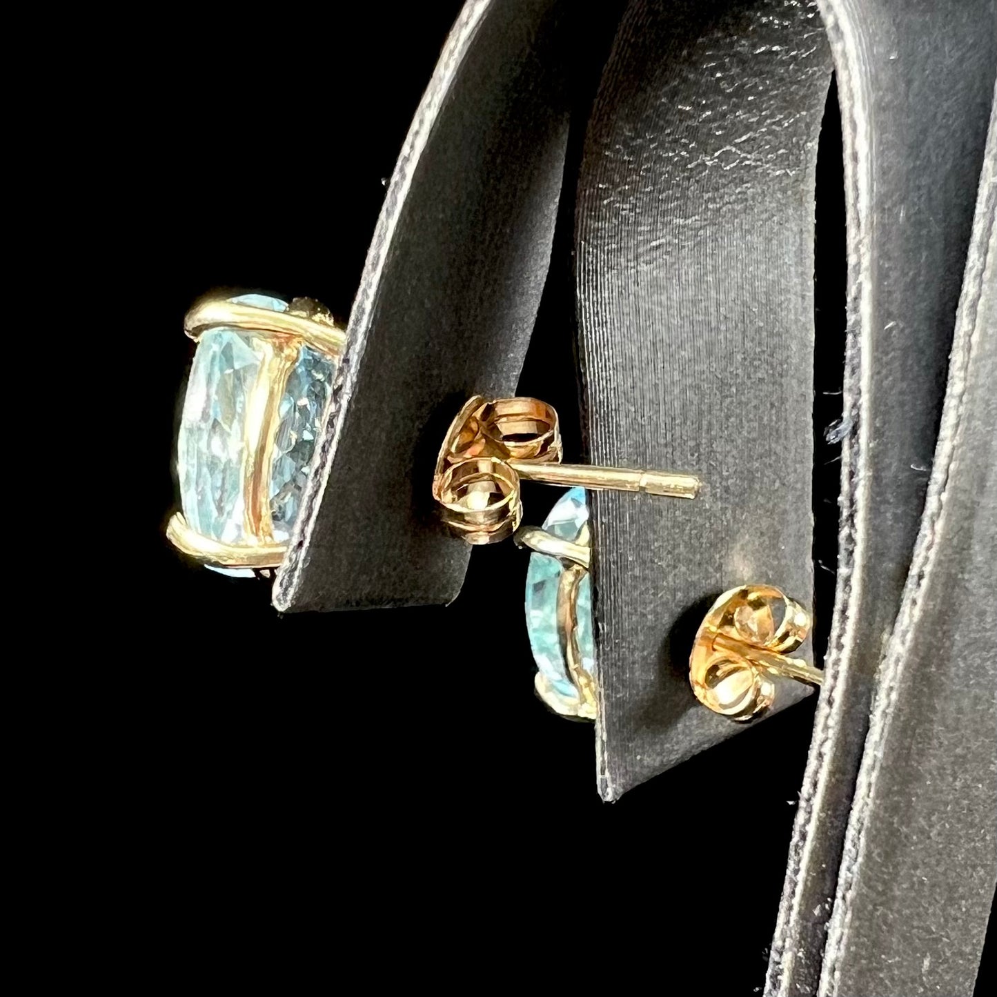 A pair of yellow gold push-back blue topaz stud earrings.