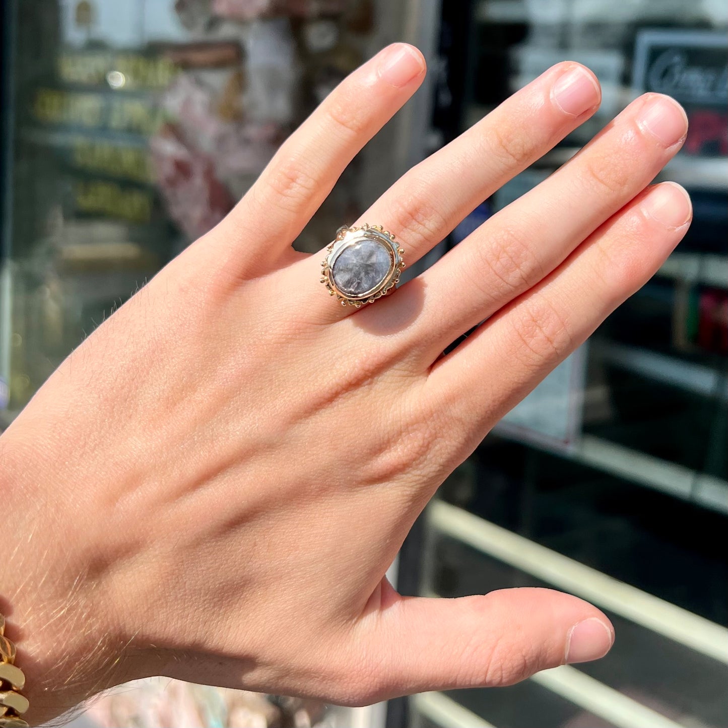 A ladies' yellow gold solitaire ring mounted with a gray trapiche star sapphire.