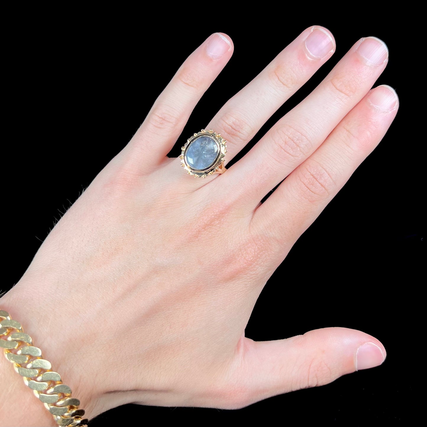 A ladies' yellow gold solitaire ring mounted with a gray trapiche star sapphire.