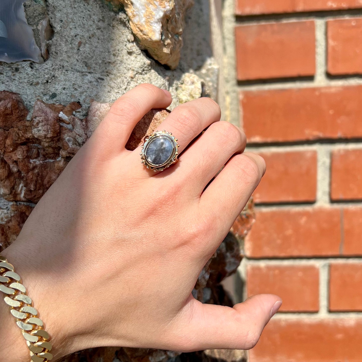 A ladies' yellow gold solitaire ring mounted with a gray trapiche star sapphire.