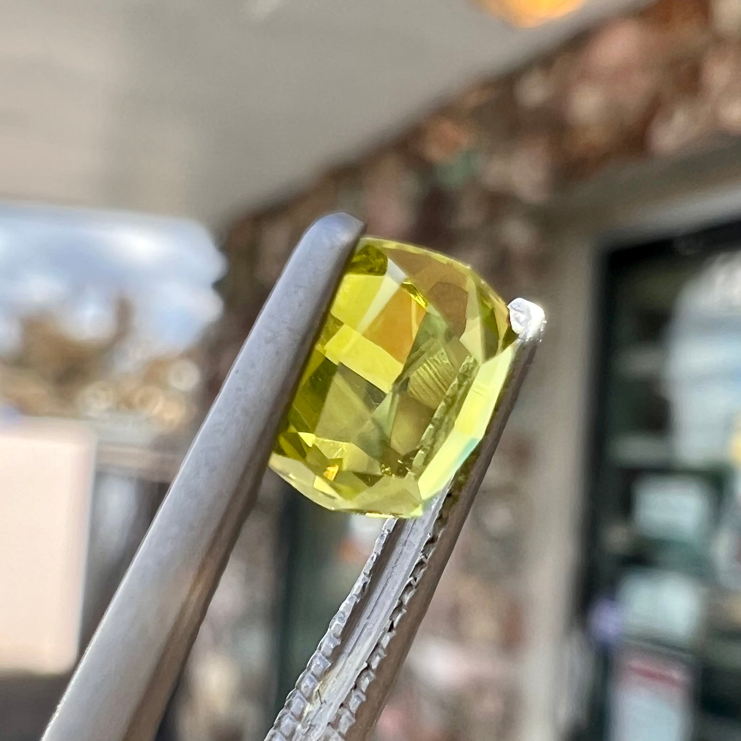A loose, modified cushion cut greenish yellow chrysoberyl gemstone.