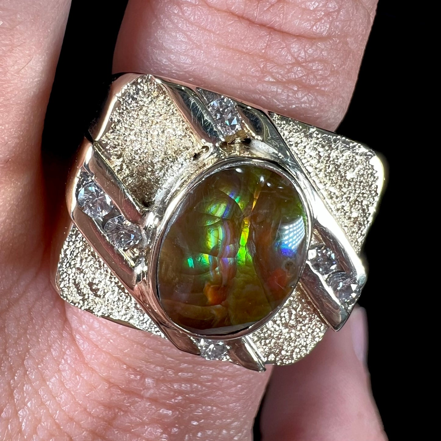 A yellow gold men's ring channel set with diamonds and bezel set with a Mexican fire agate stone.