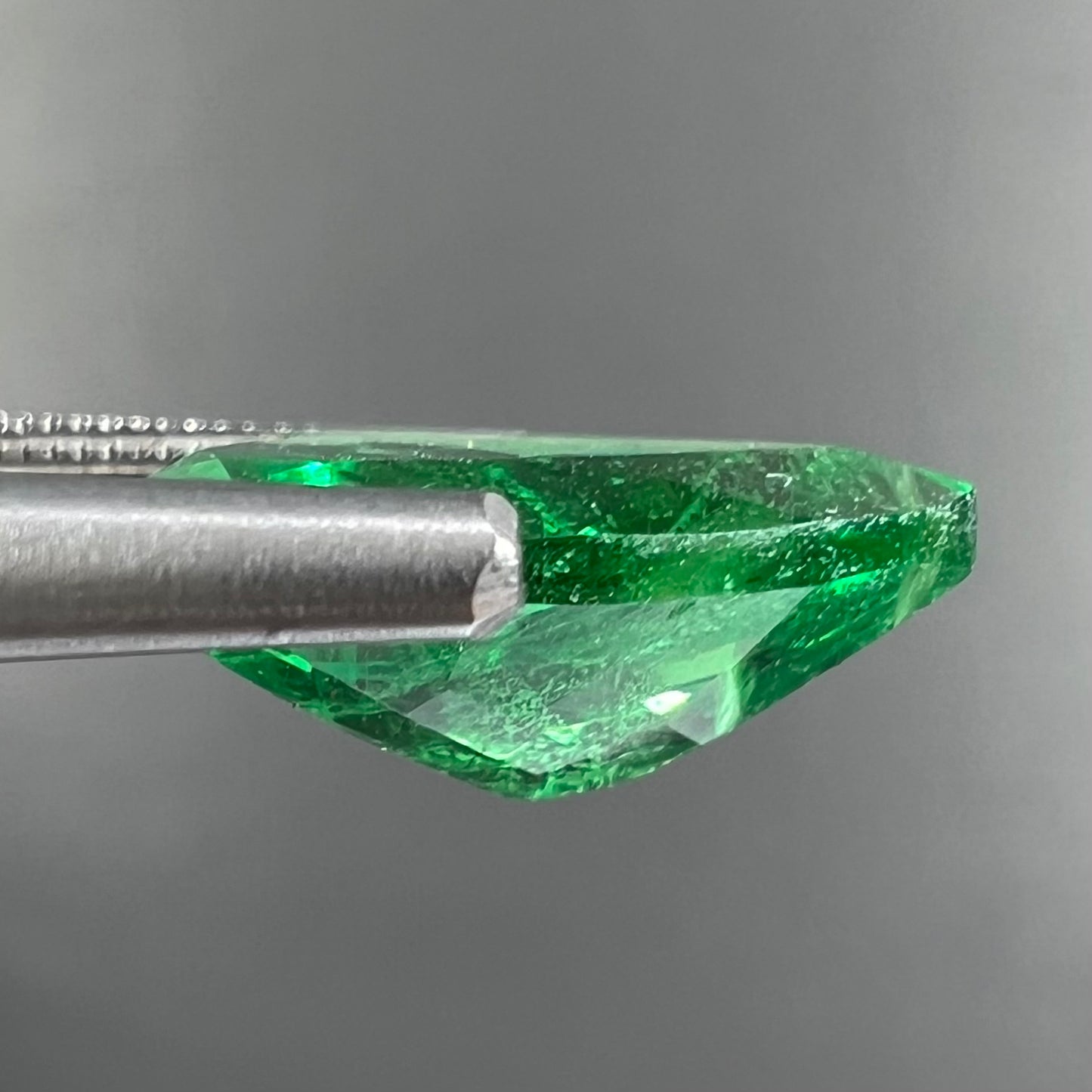 A loose, pear shaped tsavorite garnet gemstone. The stone is vivid green color.