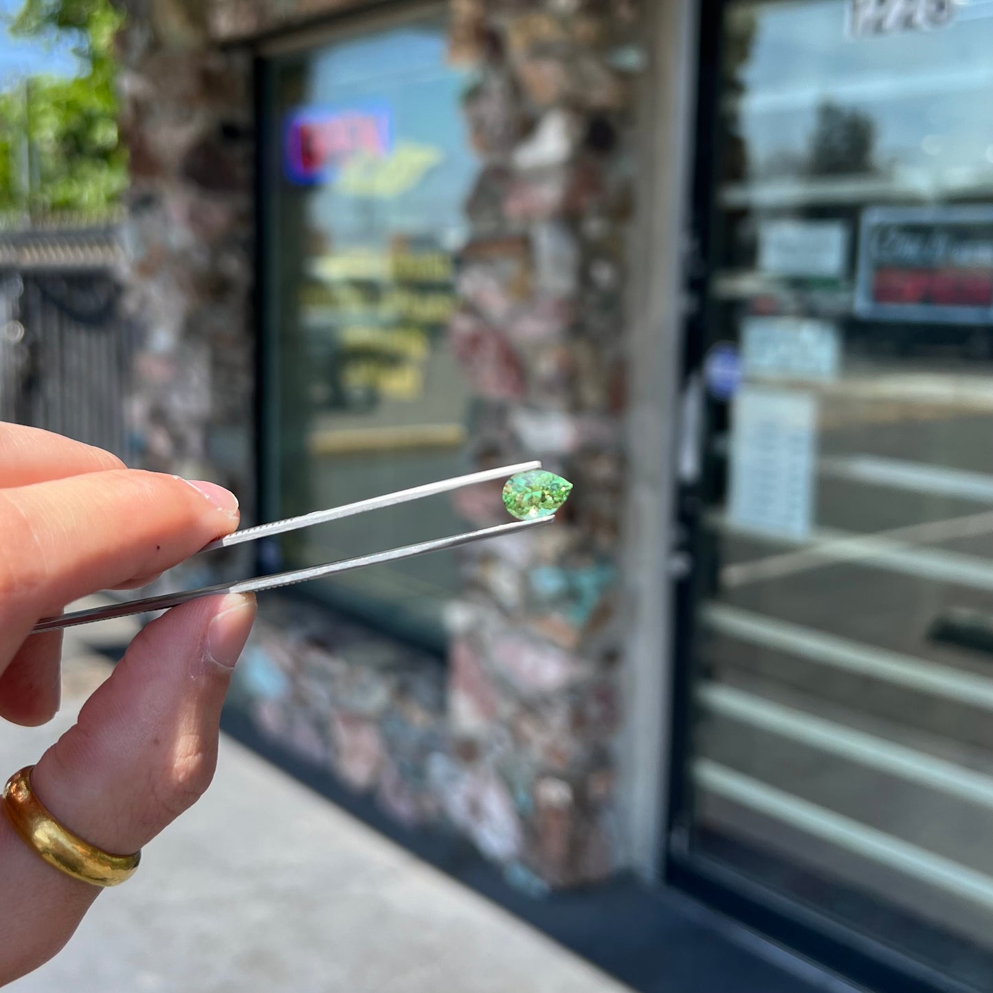 A loose, pear shaped tsavorite garnet gemstone. The stone is yellowish green.