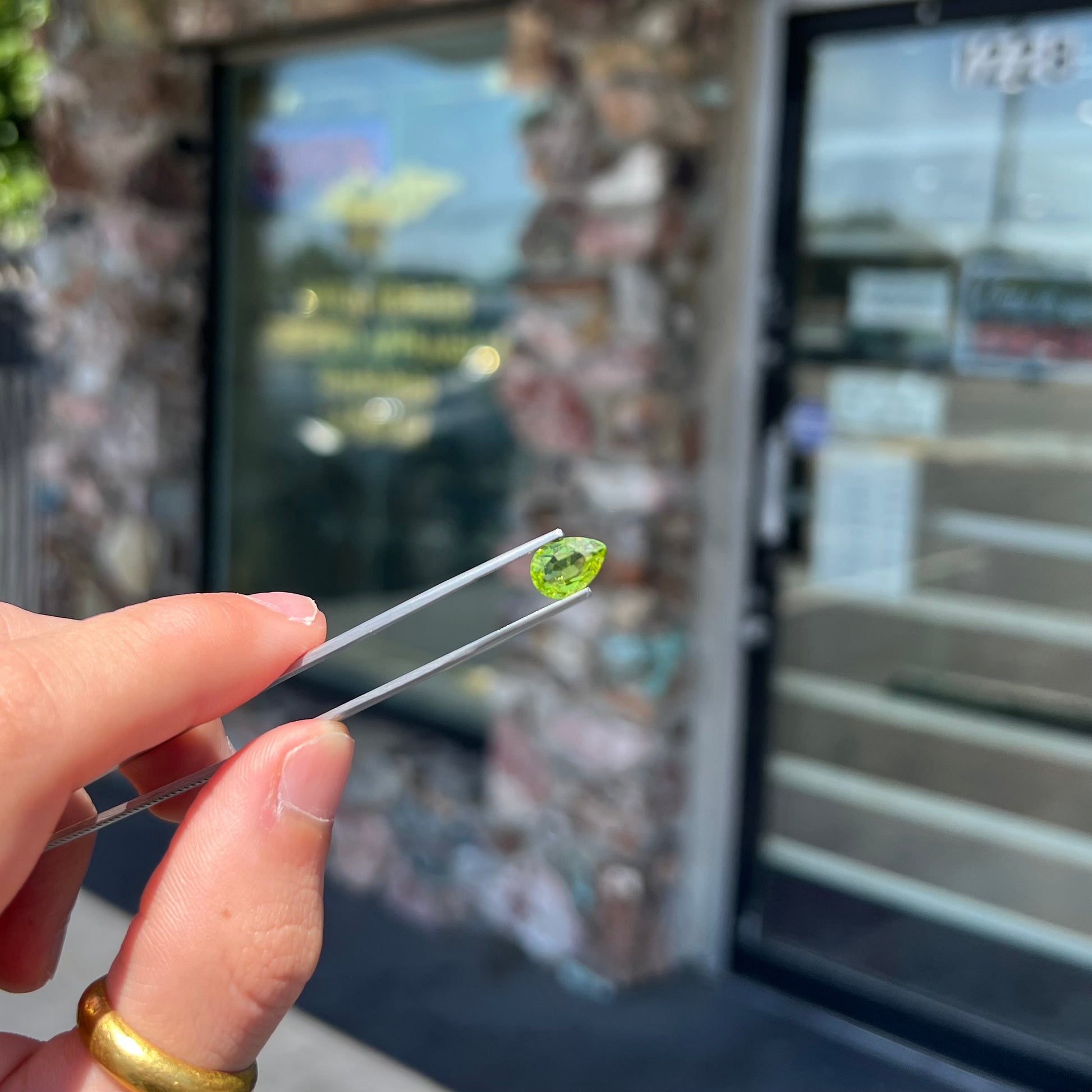 A loose, yellow green, pear shaped peridot gemstone.