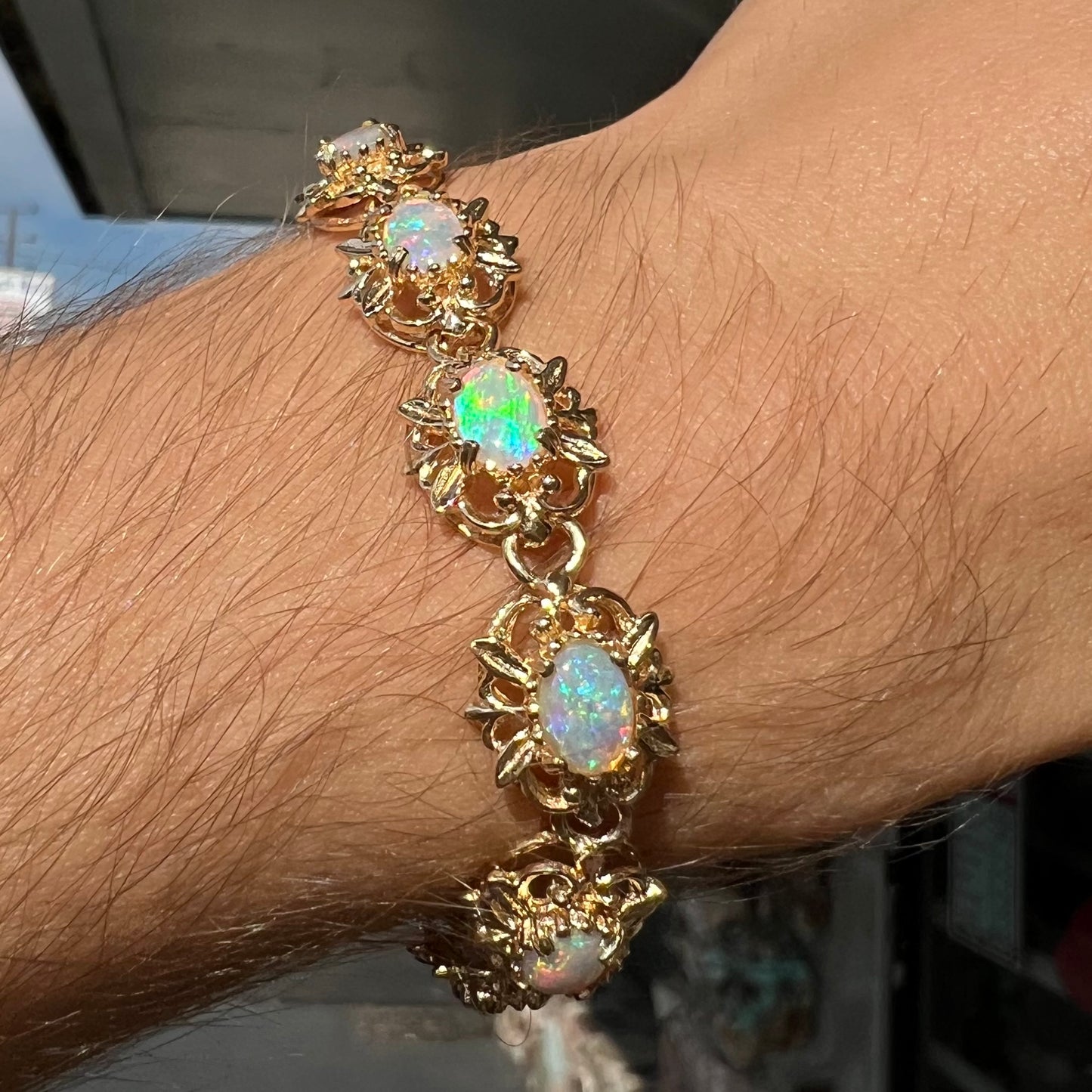 A ladies' yellow gold bracelet set with natural, oval cabochon cut white crystal opals.