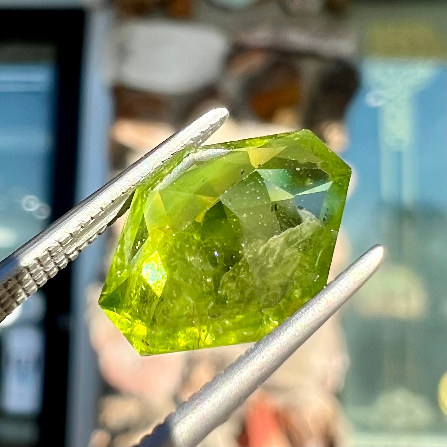 A loose, modified octagon peridot stone. The stone is a yellow green color.
