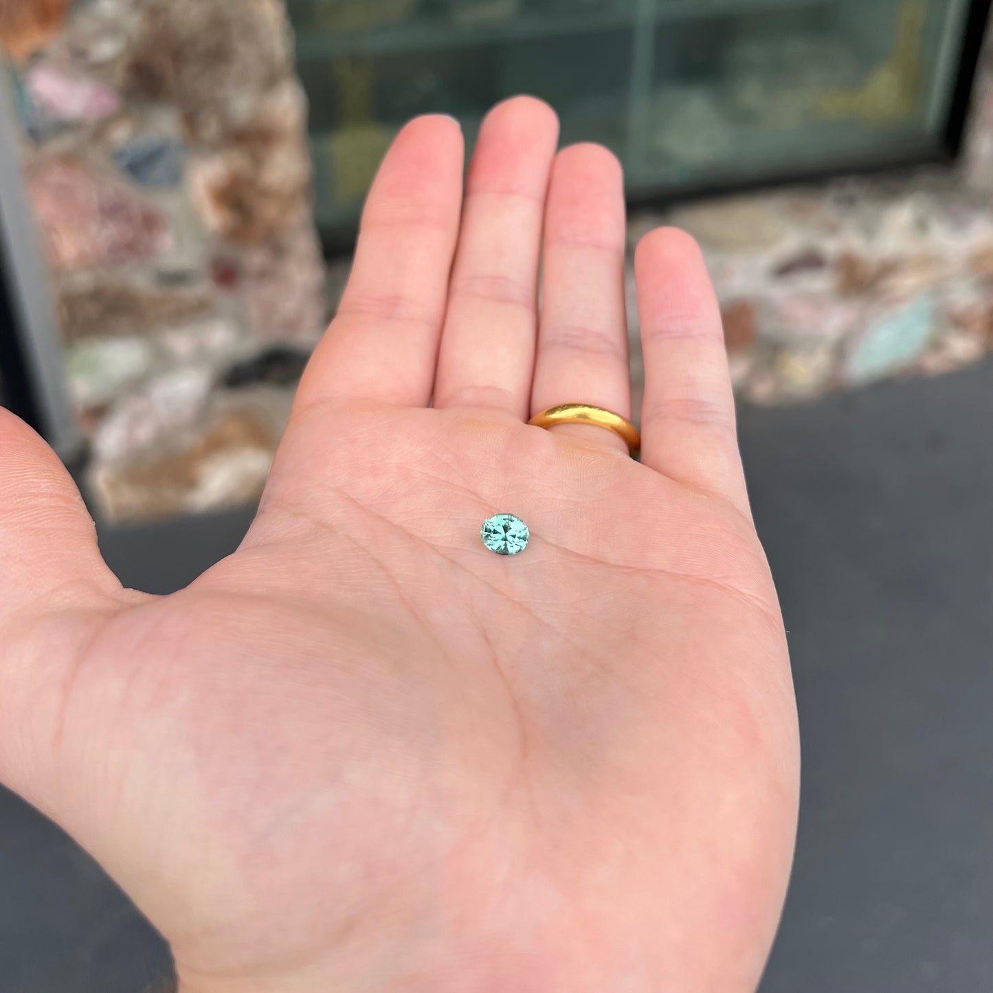 A loose, faceted modified oval cut mint green tourmaline gemstone.