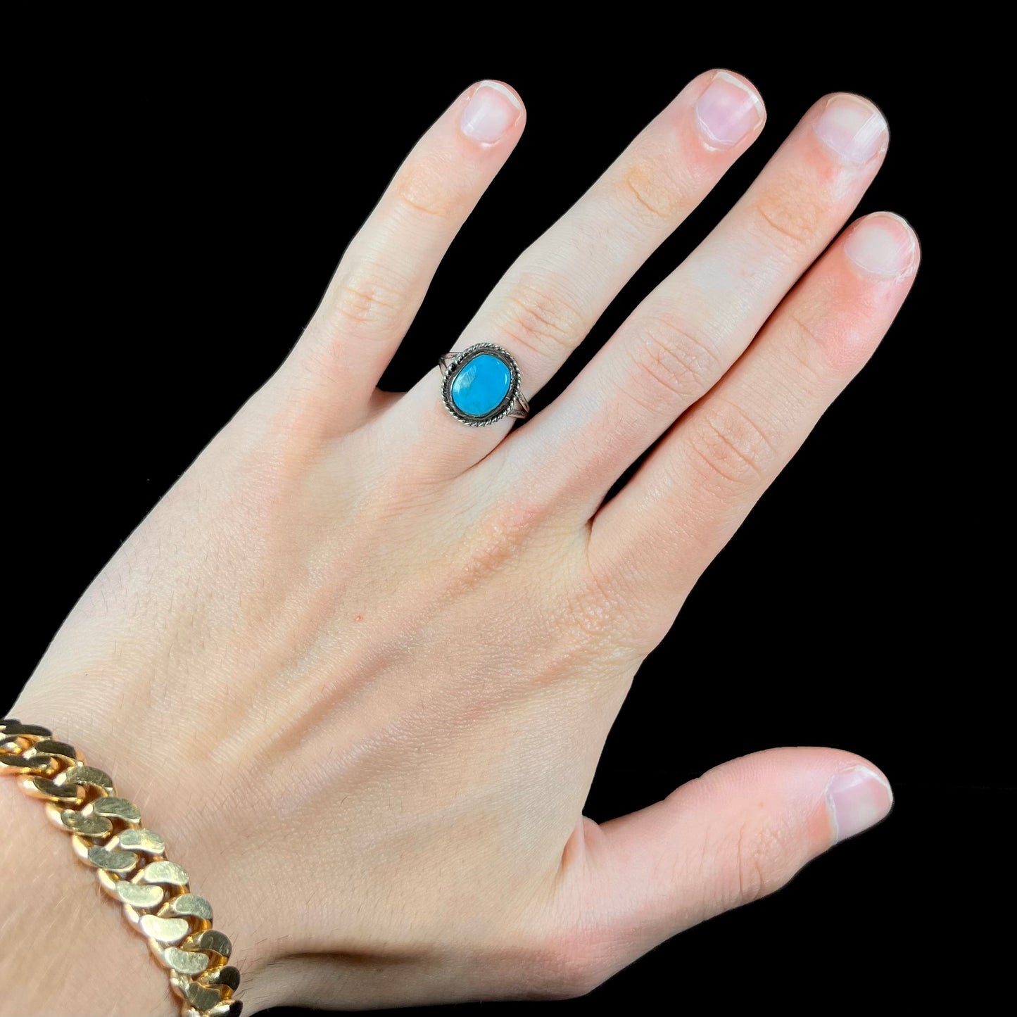 A vintage ladies' Pilot Mountain turquoise ring handmade in sterling silver with a rope accented bezel.