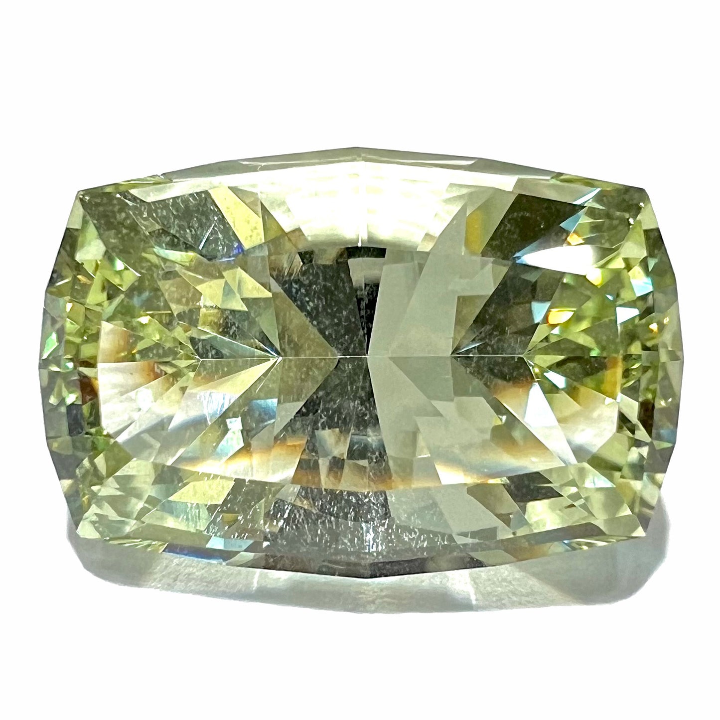 A loose, modified cushion cut heliodor beryl gemstone. The stone is a yellow-green color and weighs 31.28 carats.