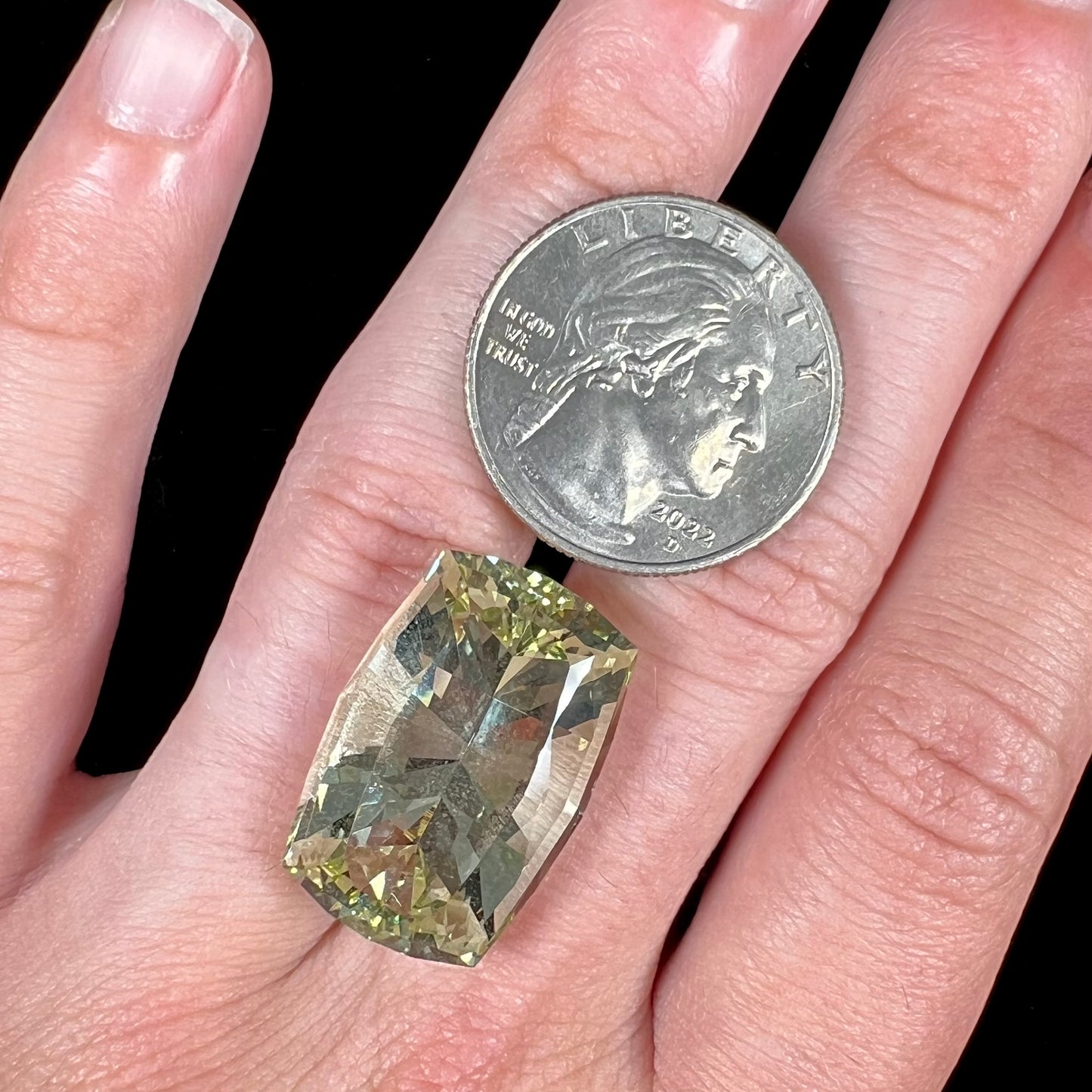 A loose, modified cushion cut heliodor beryl gemstone. The stone is a yellow-green color.