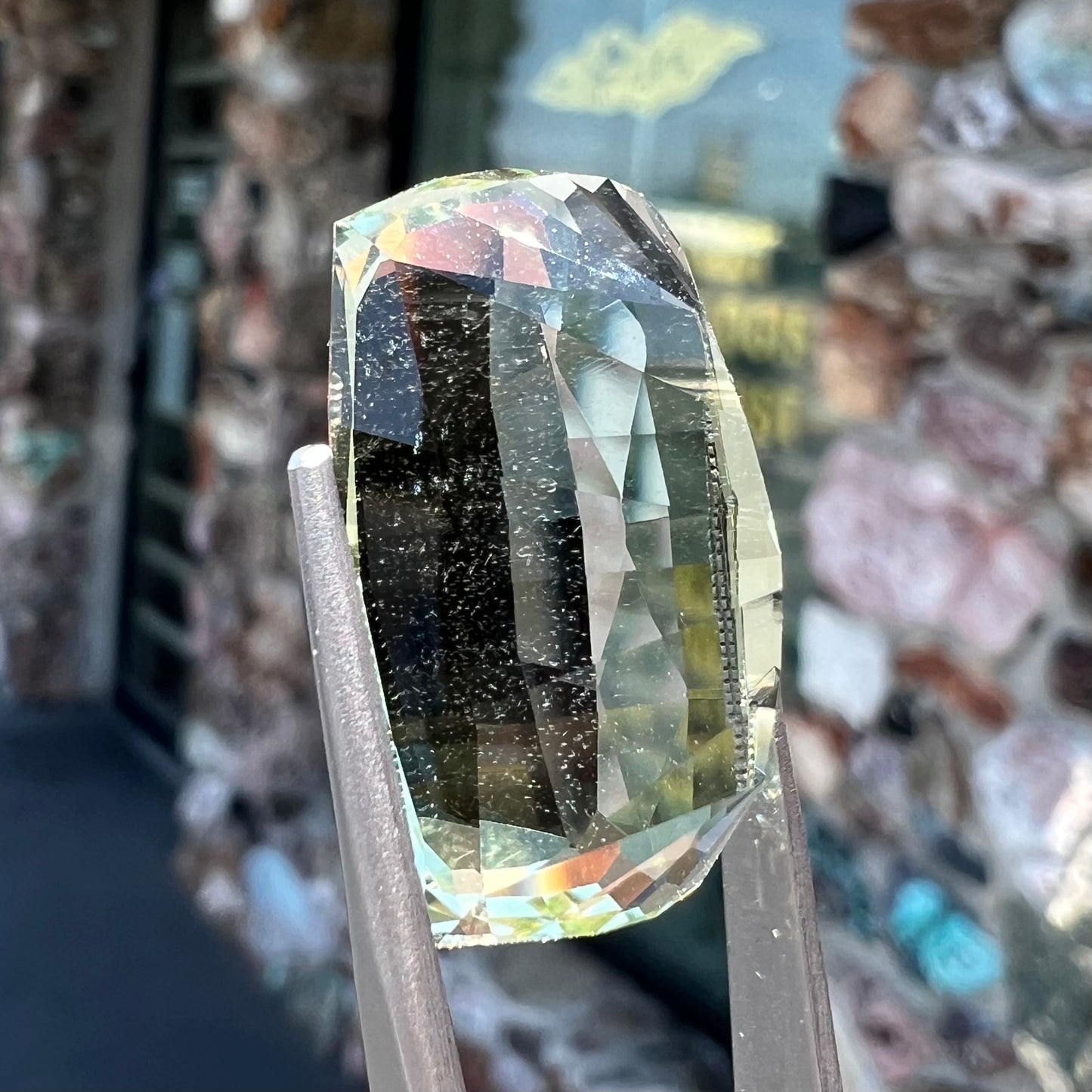 A loose, modified cushion cut heliodor beryl gemstone. The stone is a yellow-green color.