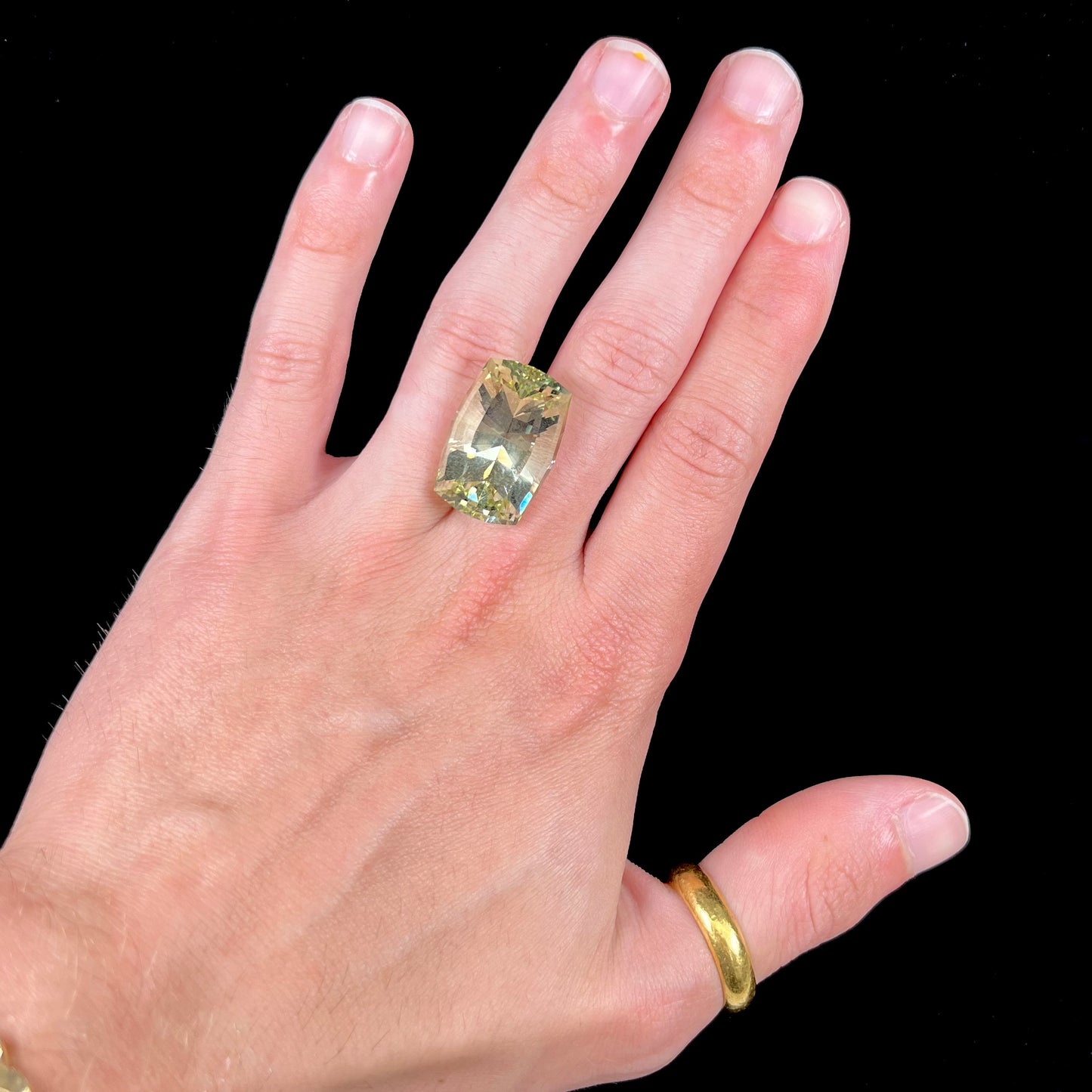 A loose, modified cushion cut heliodor beryl gemstone. The stone is a yellow-green color.