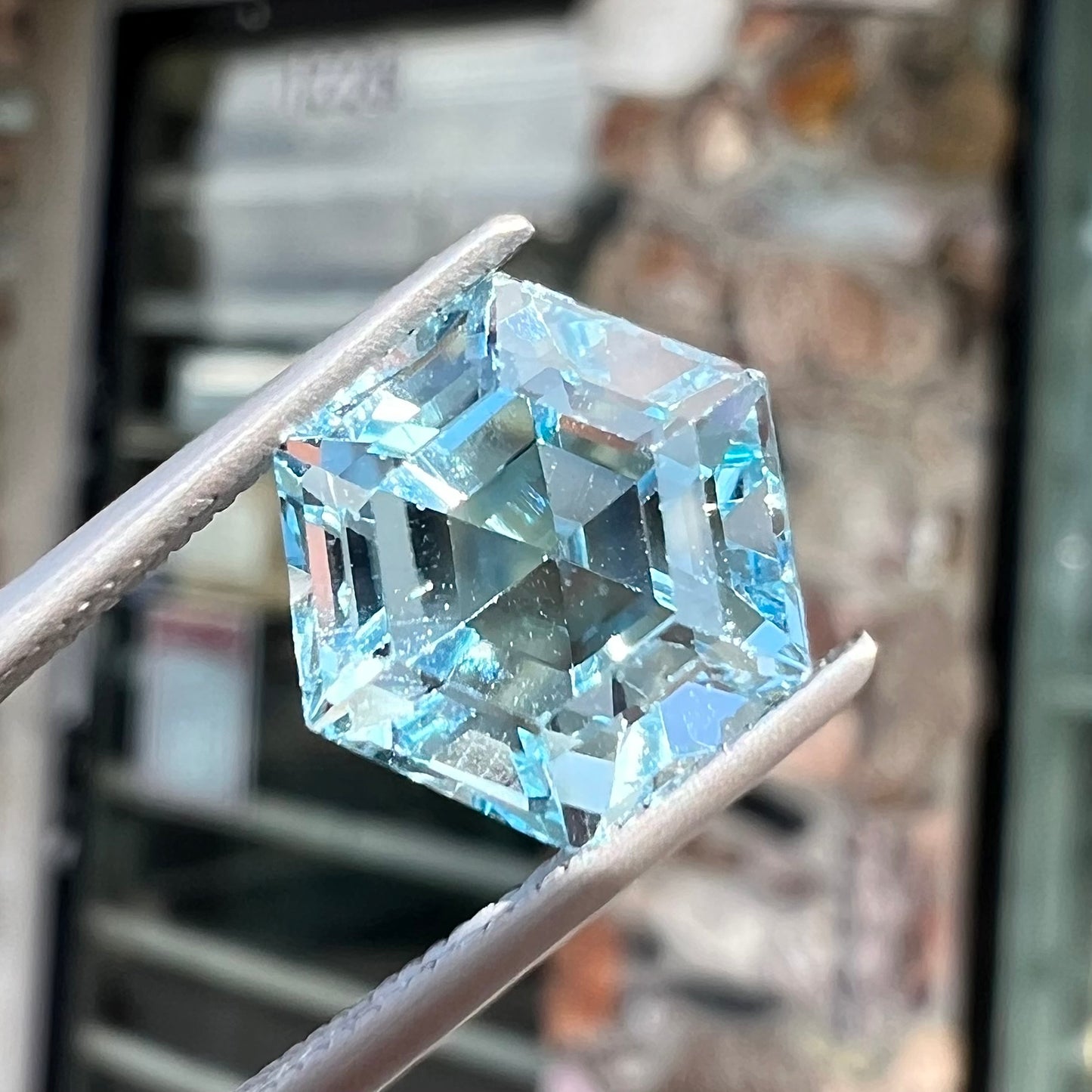 A faceted hexagon cut sky blue topaz gemstone.