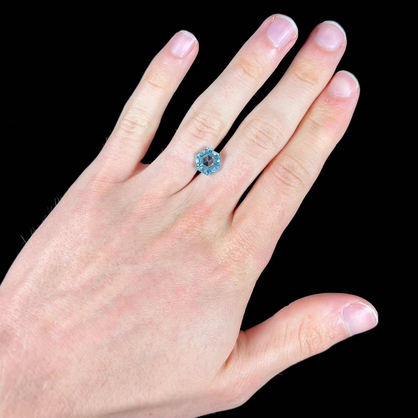 A faceted hexagon cut sky blue topaz gemstone.