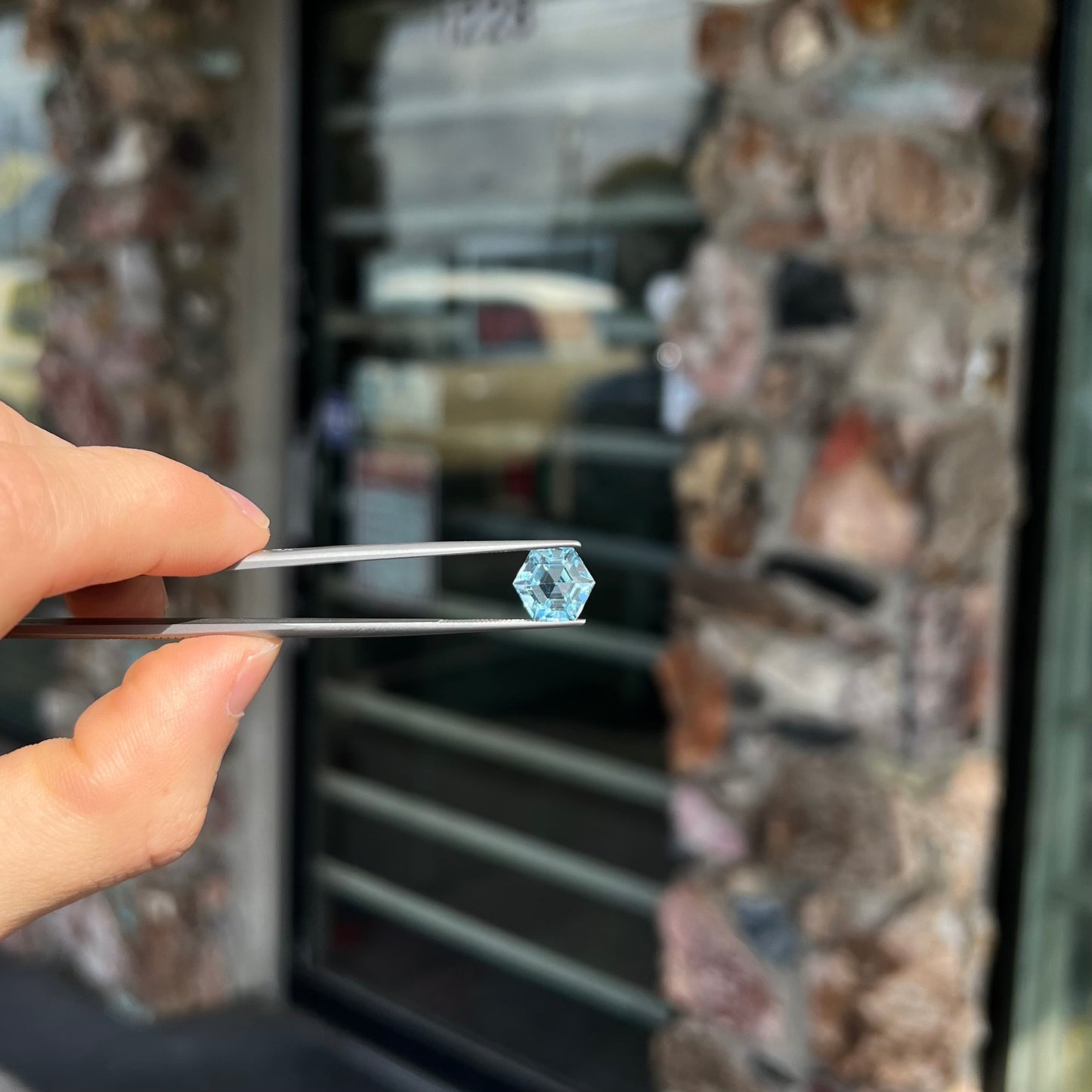 A faceted hexagon cut sky blue topaz gemstone.