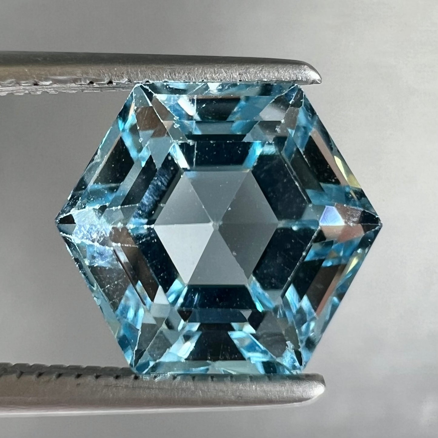 A faceted hexagon cut sky blue topaz gemstone.
