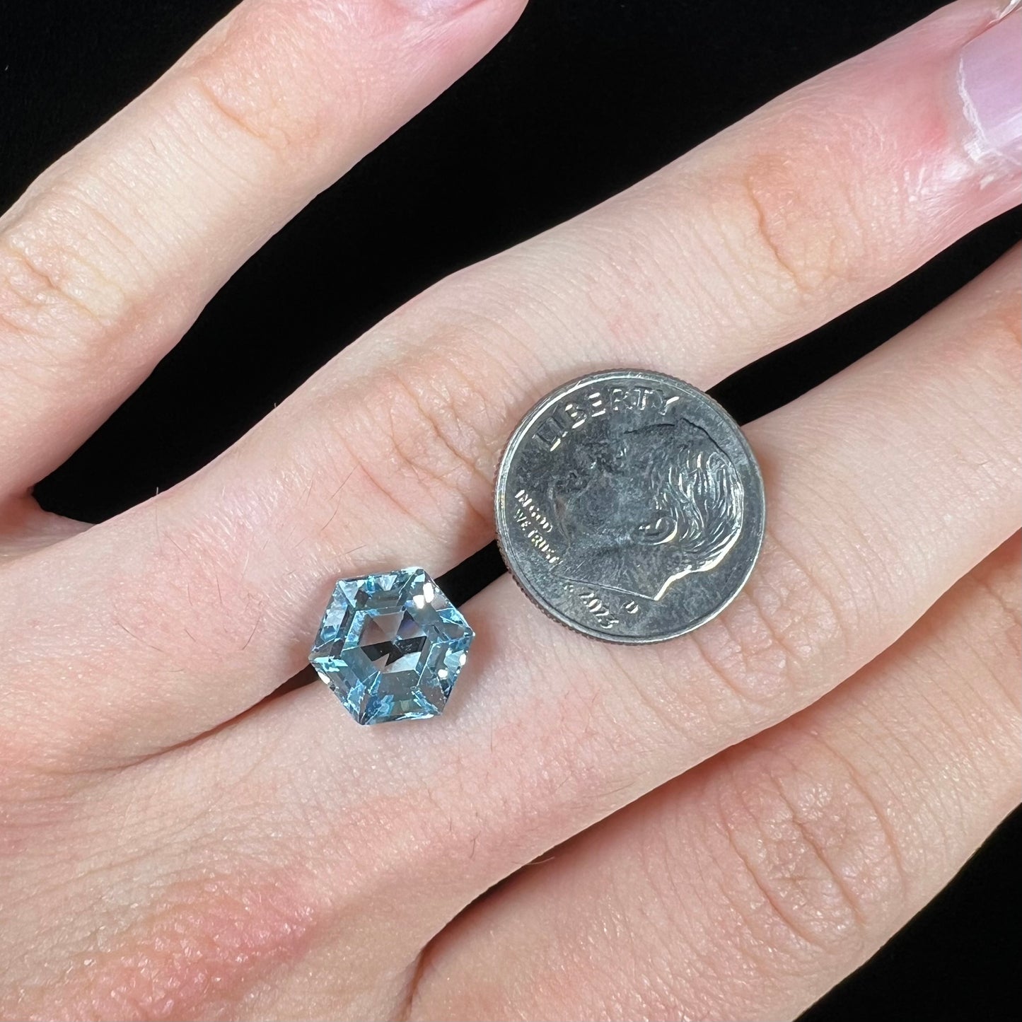 A faceted hexagon cut sky blue topaz gemstone.