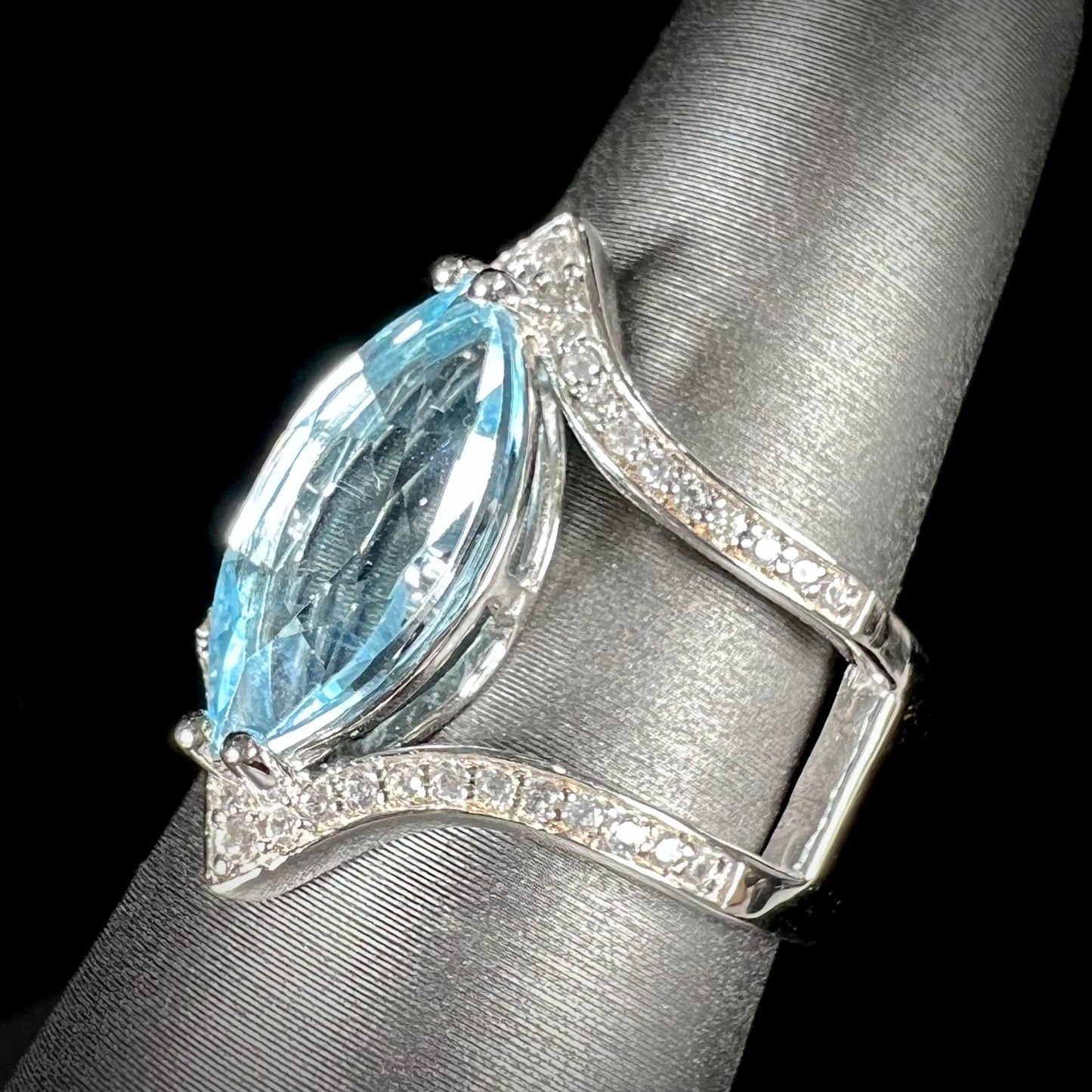 A ladies' marquise cut blue topaz and cubic zirconia accented ring cast in sterling silver.