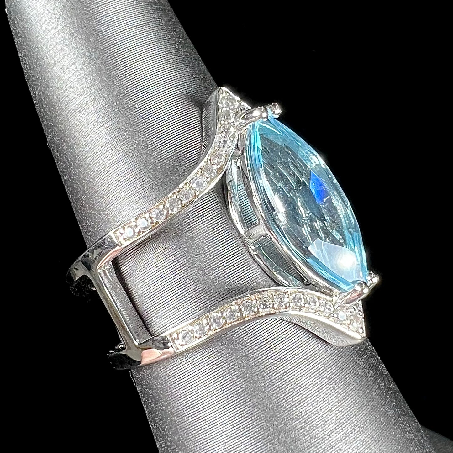 A ladies' marquise cut blue topaz and cubic zirconia accented ring cast in sterling silver.