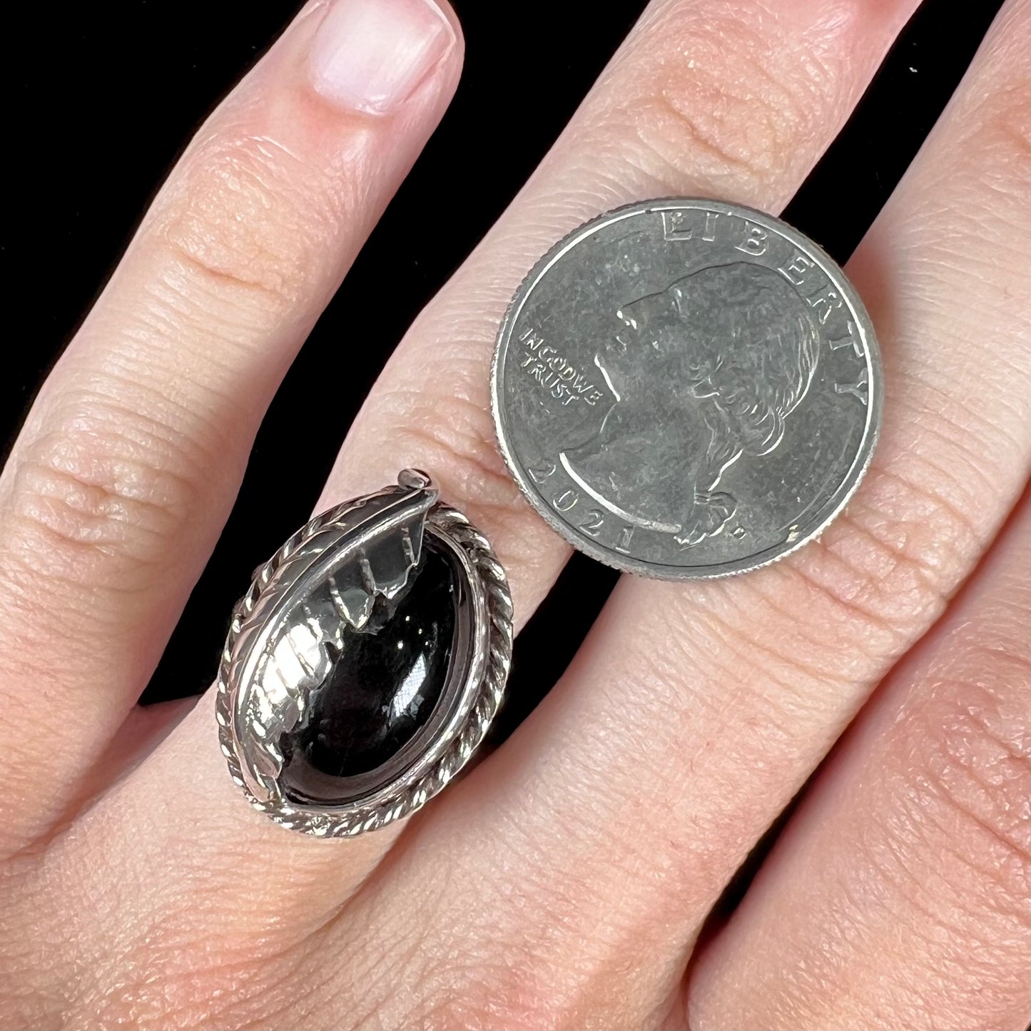 A sterling silver unisex black onyx feather ring.