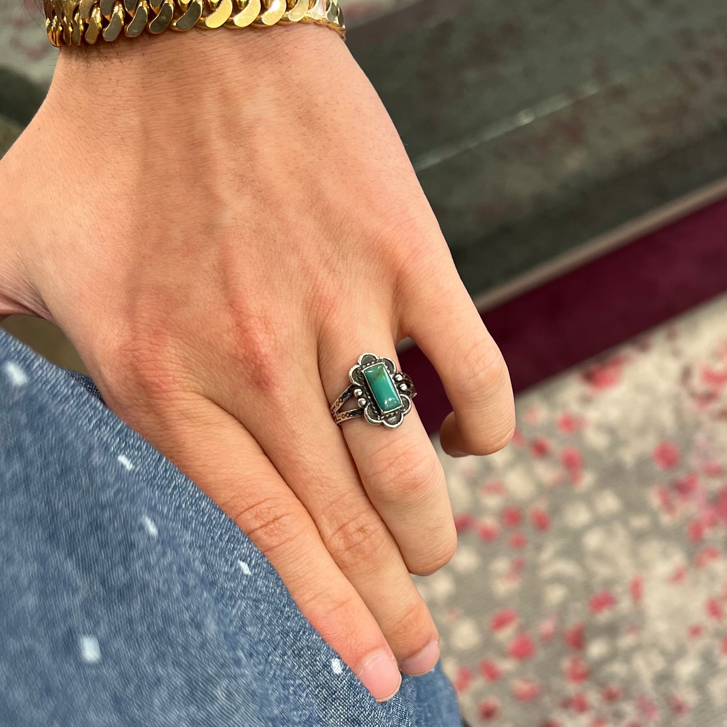 A ladies' silver ring stamped with Southwest style designs and set with a rectangular cabochon cut Royston turquoise stone.