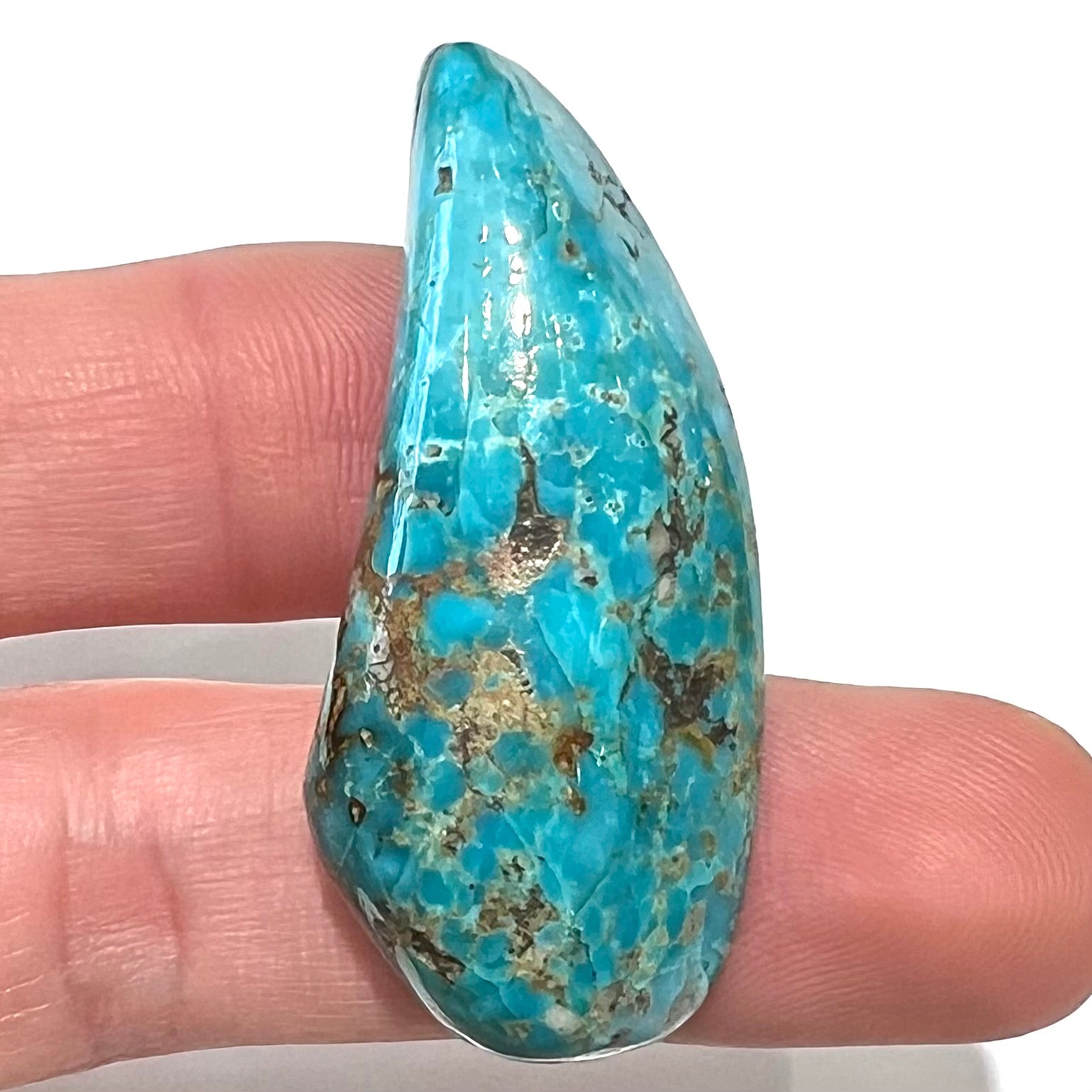 A loose, freeform cabochon cut Kingman turquoise stone from Arizona.  The stone is blue with gray and brown matrix.