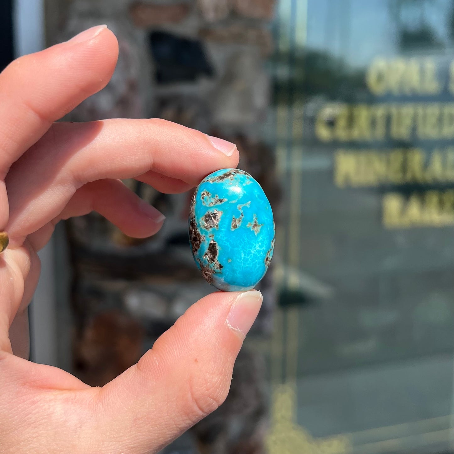 A loose, oval cabochon cut turquoise stone from Kingman, Arizona.