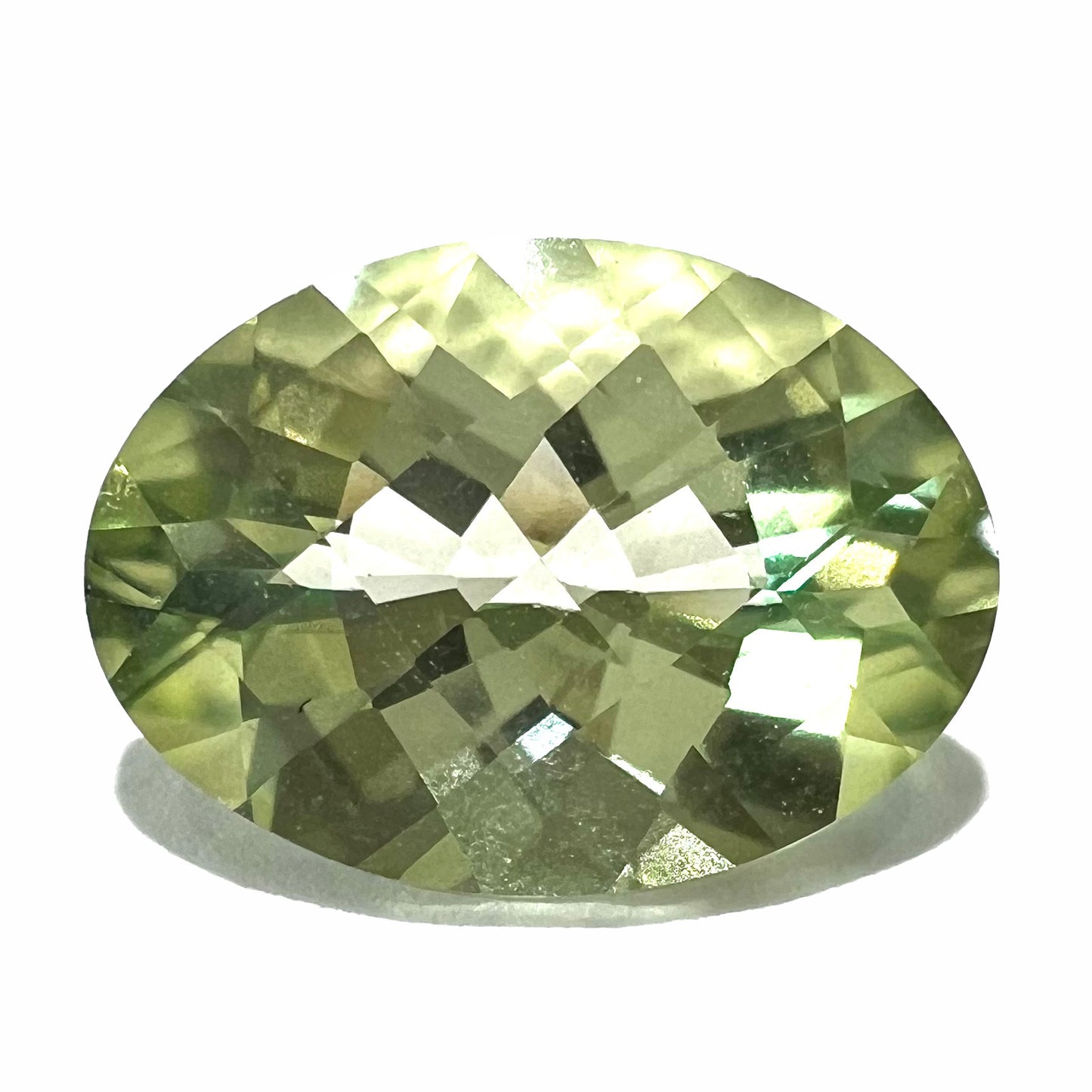 An oval checkerboard cut kiwi mystic topaz gemstone. The stone is a light yellowish green color.