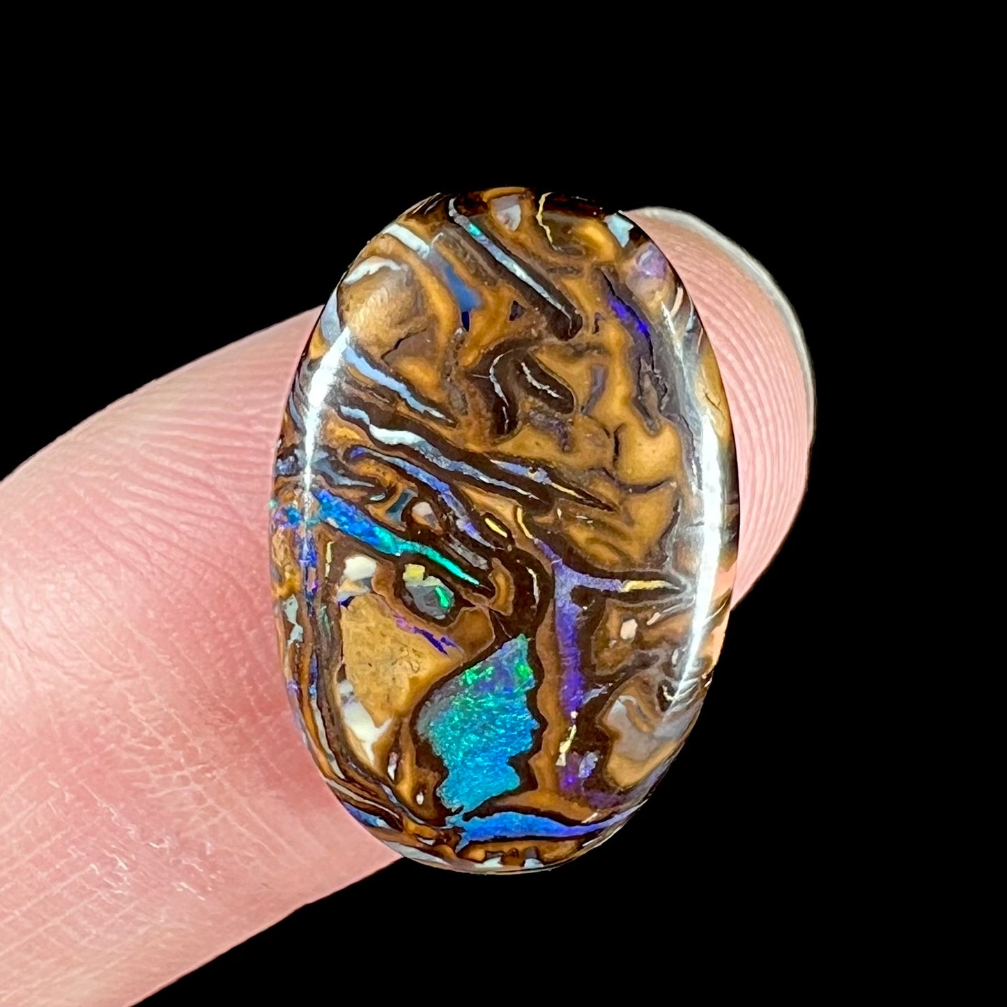 A loose boulder opal from Koroit, Australia. There is a picture of a face in the stone.