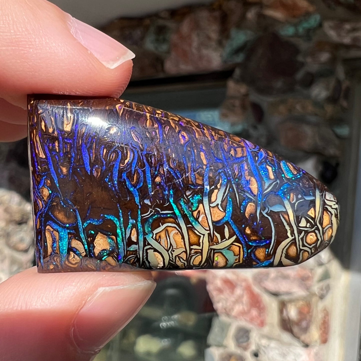 A loose boulder opal stone from Koroit, Australia. The opal has a blue and purple pattern.