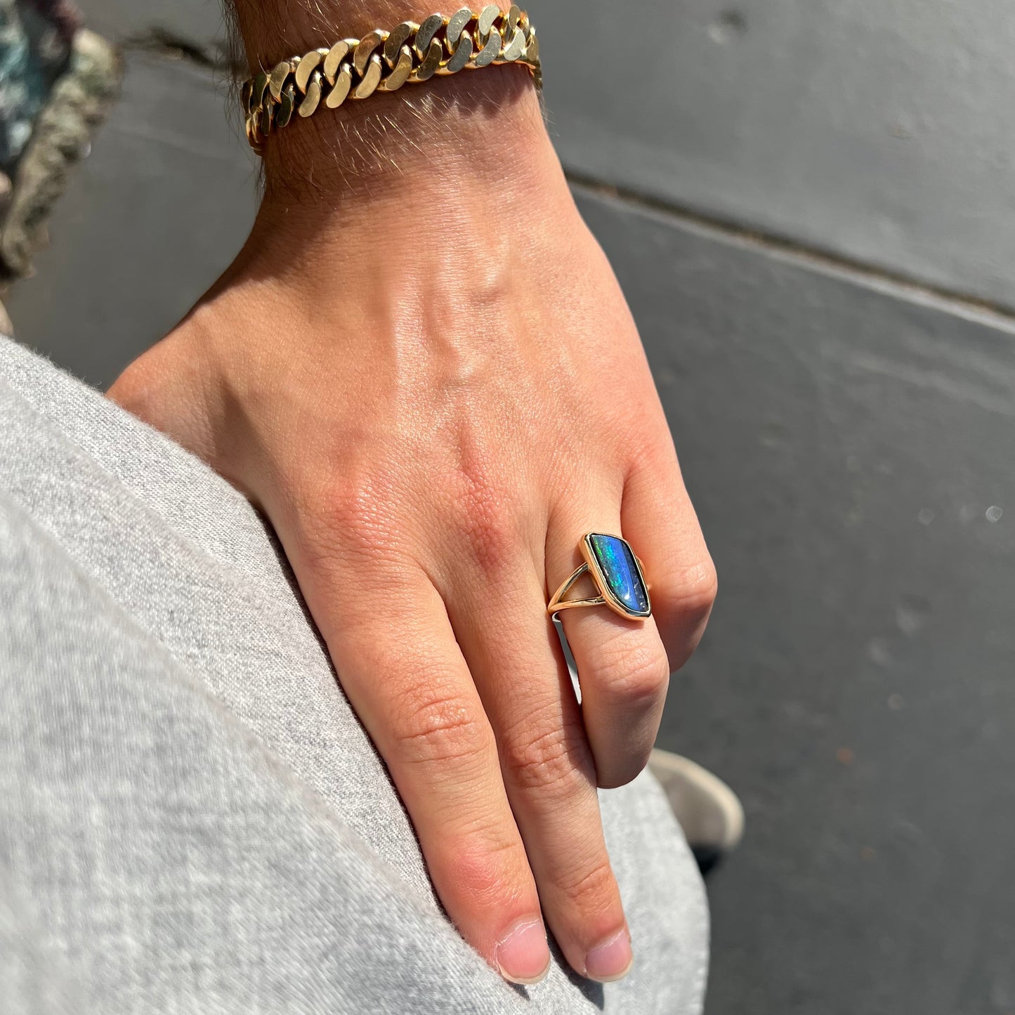 A ladies' split shank gold ring bezel set with a natural, Australian black boulder opal.