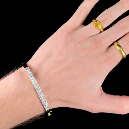 A ladies' hinged yellow gold bangle bracelet set with 50 Standard Round Brilliant Cut diamonds.