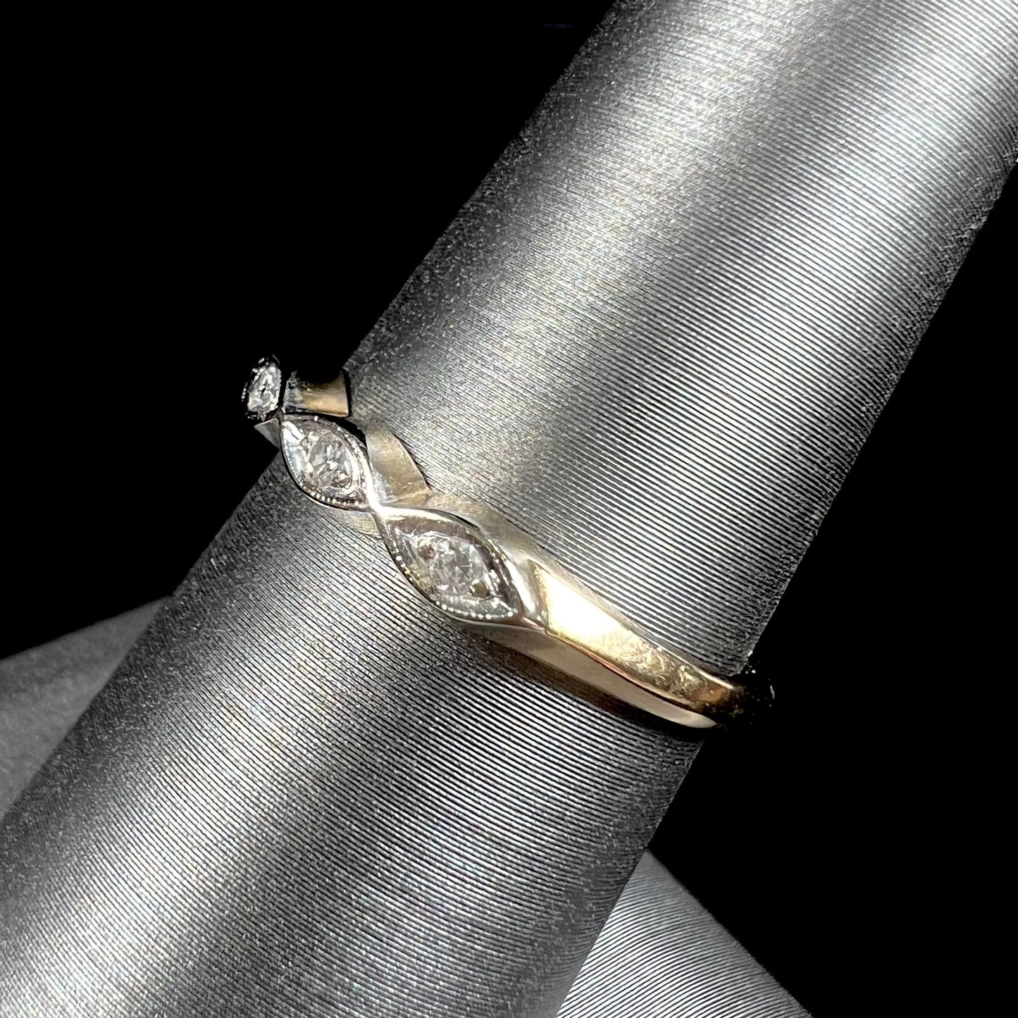 A vintage, yellow gold ladies' wedding band set with three single cut diamonds in marquise shaped designs.