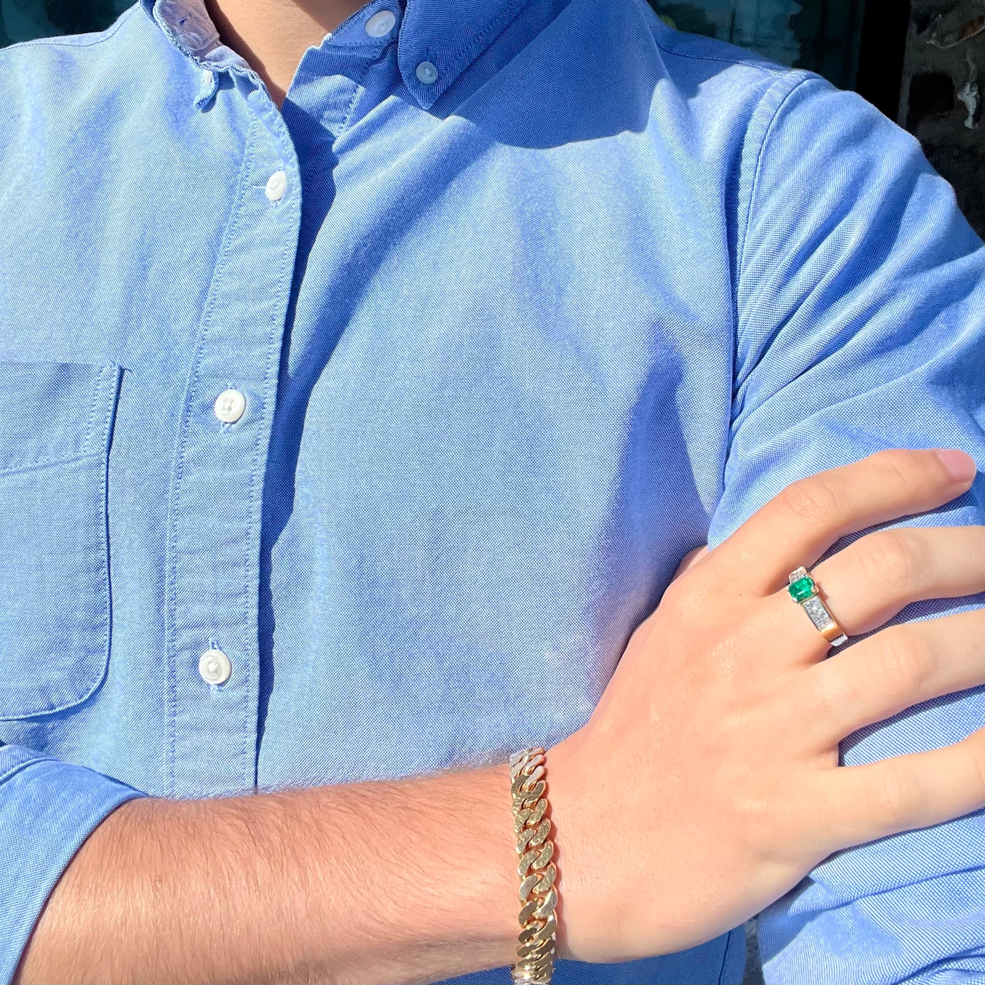 An 18 karat yellow gold ladies' emerald ring, channel set with princess cut diamonds.