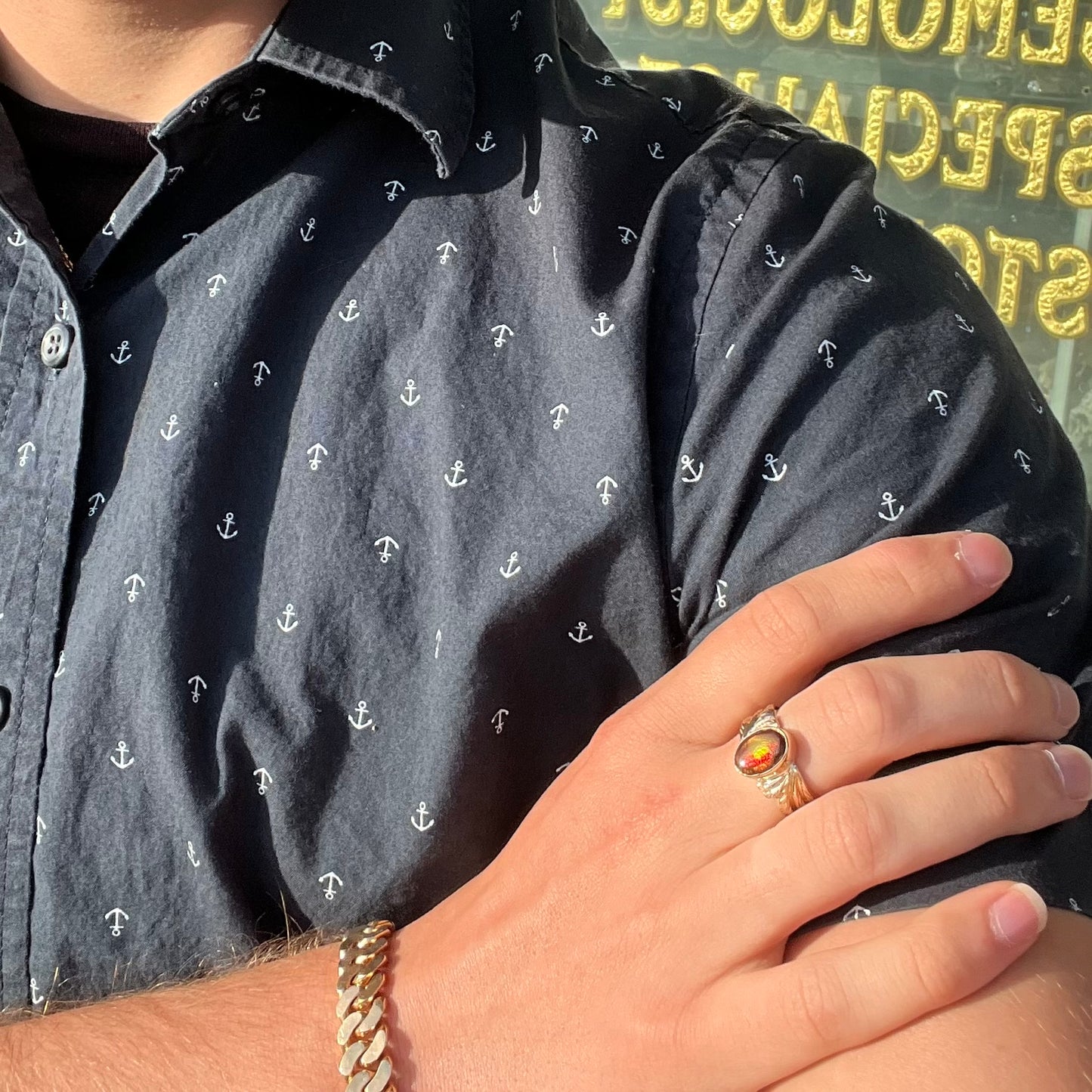 A unisex oval cabochon cut fire agate ring cast in yellow gold. The stone flashes green and red colors.