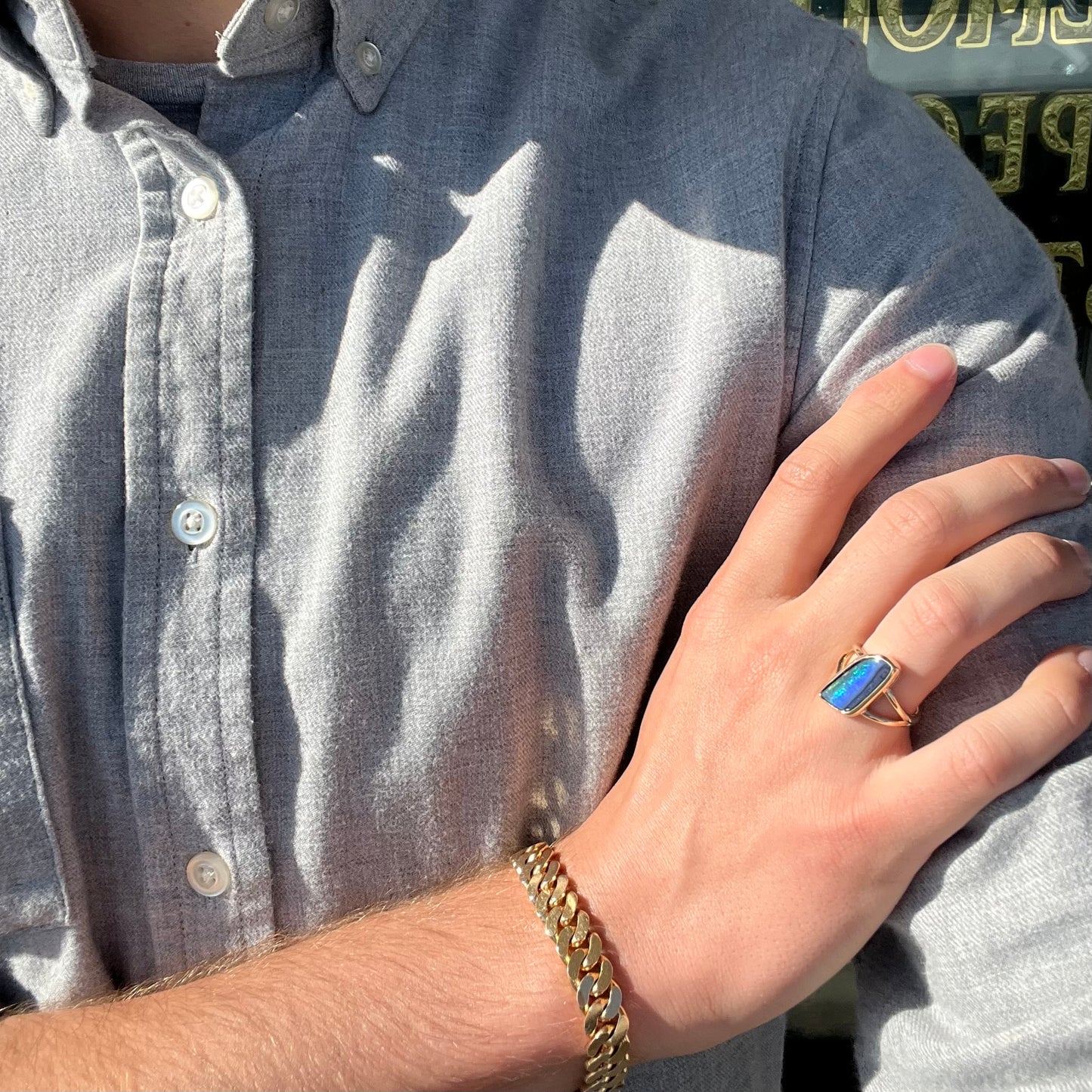 A ladies' split shank gold ring bezel set with a natural, Australian black boulder opal.